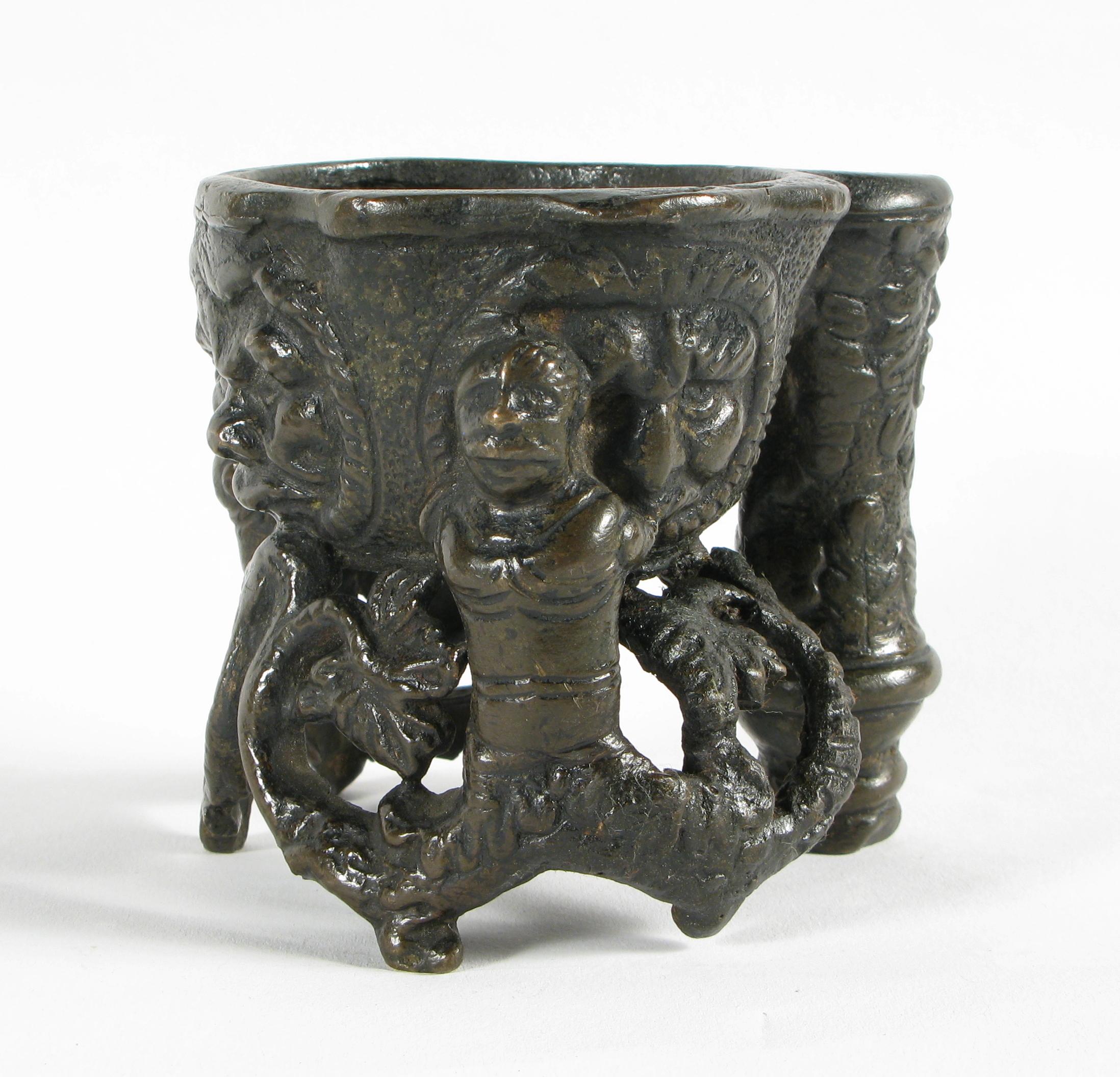 Encrier en bronze coulé à la cire perdue, XVIe siècle

Vase central de forme ovale pour l'encre, magistralement décoré par quatre masques aux physionomies et expressions différentes.
 
A l'appui, deux Sirenes dont les queues se terminent par des
