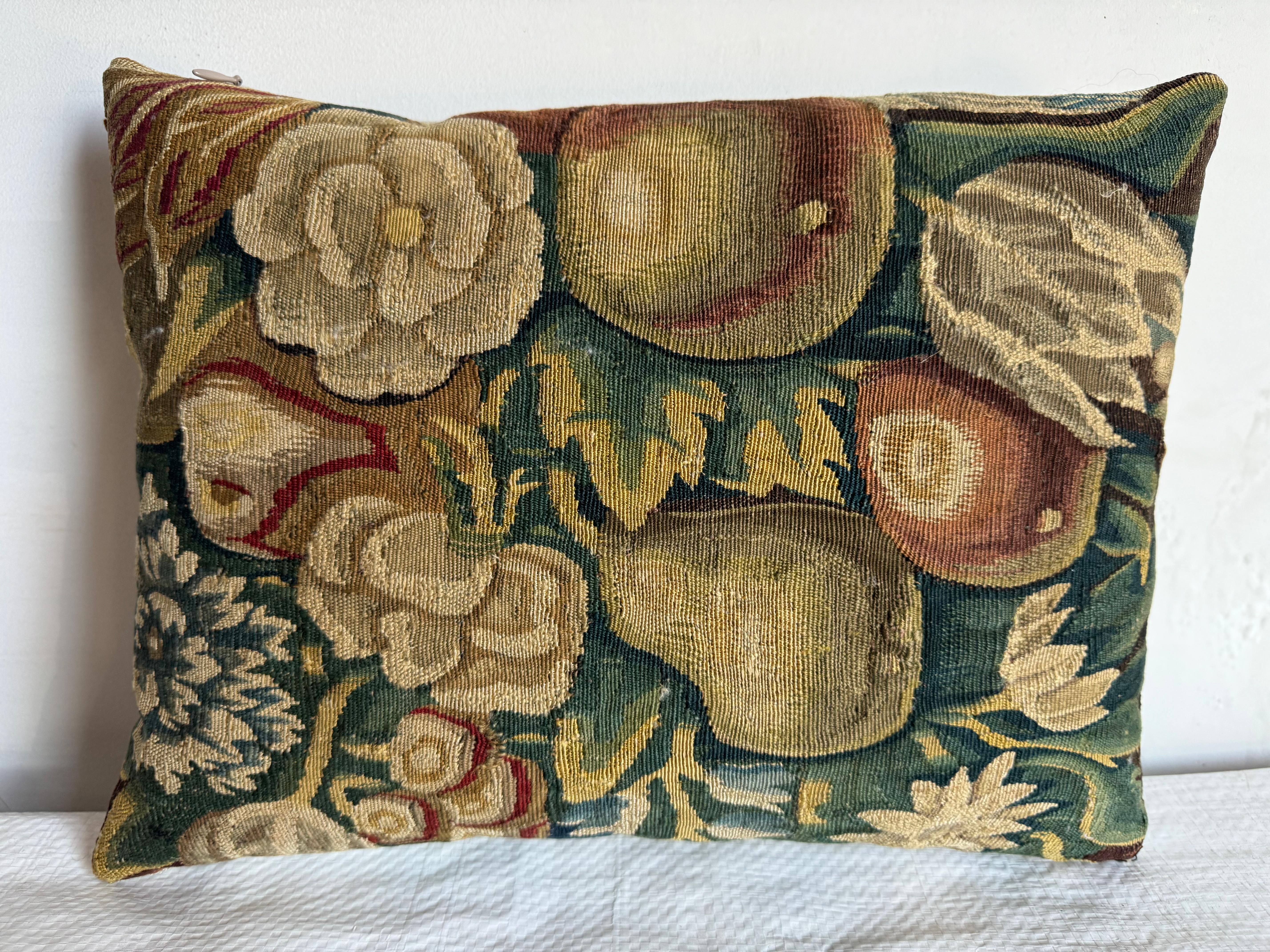 Cet exquis coussin vintage met en valeur un riche motif de tapisserie bruxelloise du XVIe siècle, orné de fruits vibrants et de motifs floraux dans des tons terreux. L'artisanat finement tissé reflète l'élégance historique, parfaite pour ajouter une