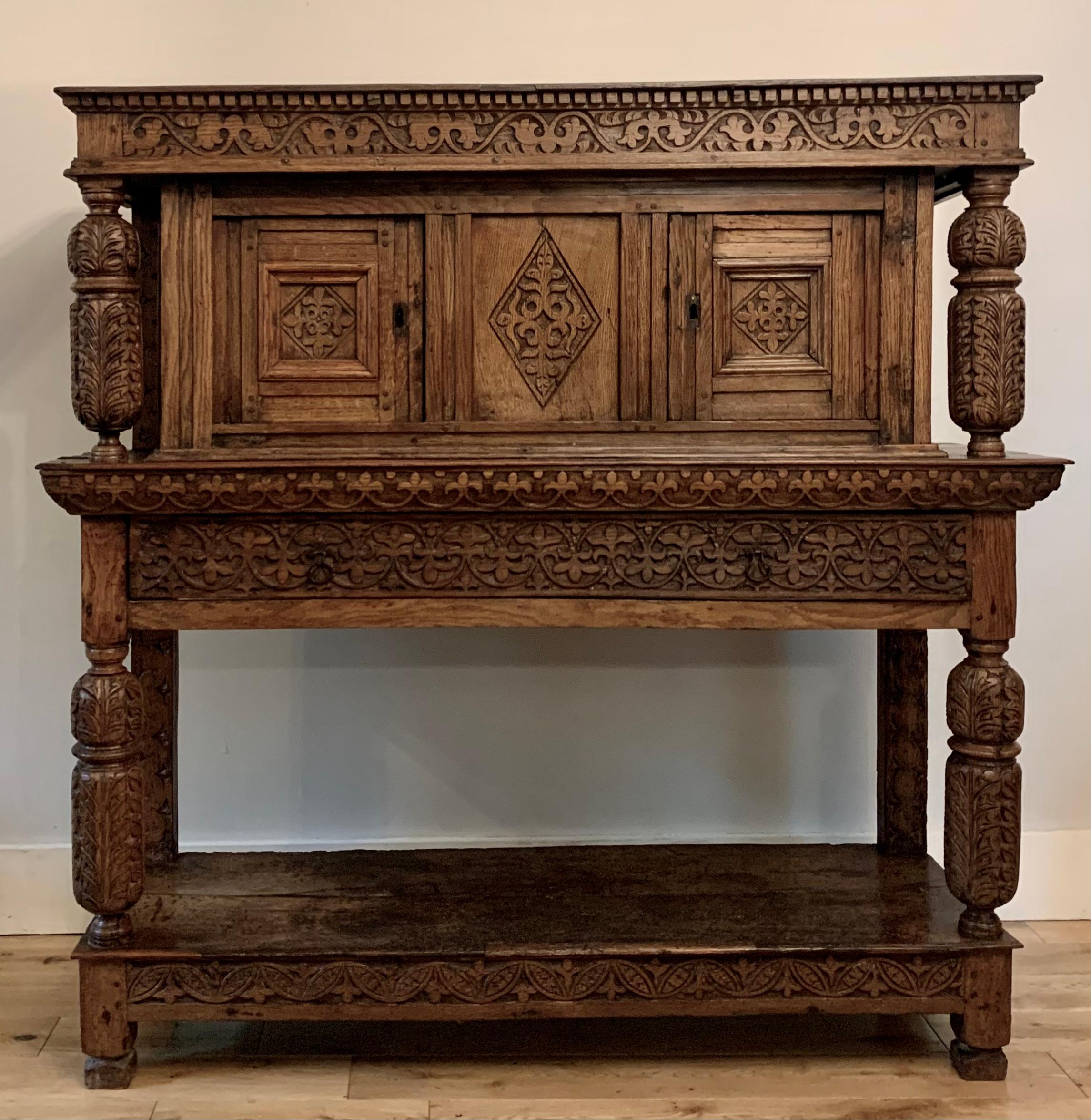 A rare Elizabethan Joined Oak Livery Cupboard , dating to the late 16th century , small proportions and of historical interest , carved with the Fleur-De-Lis . 

Wonderful colour and patina built up over a period of more than 400 years  , slightly