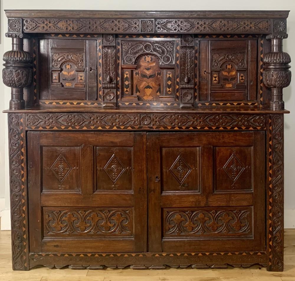 Elizabethan , Joined Oak , Court Cupboard dating to the late 16th century Circa 1600 . Elizabethan carved cup and cover columns , original candle shelf , two upper doors and central panel beautifully inlaid with holly and bog oak floral marquetry ,