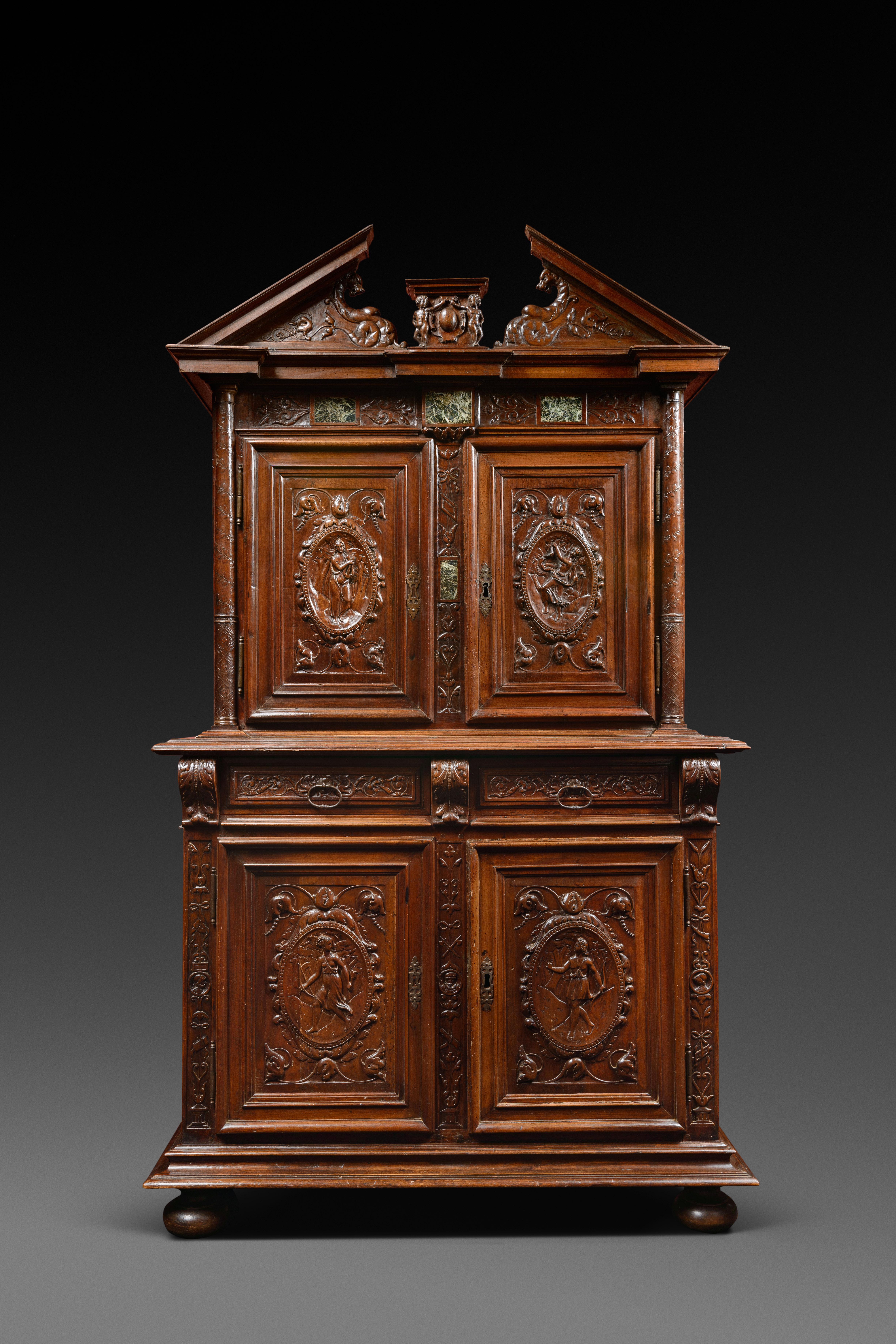 On the left post of the lower body, is written the date 1596 in a cartouche

This cabinet has two bodies. The upper part, set back, is moulded and carved. At the bottom, the cabinet opens with two doors surmounted by two drawers, and at the top by