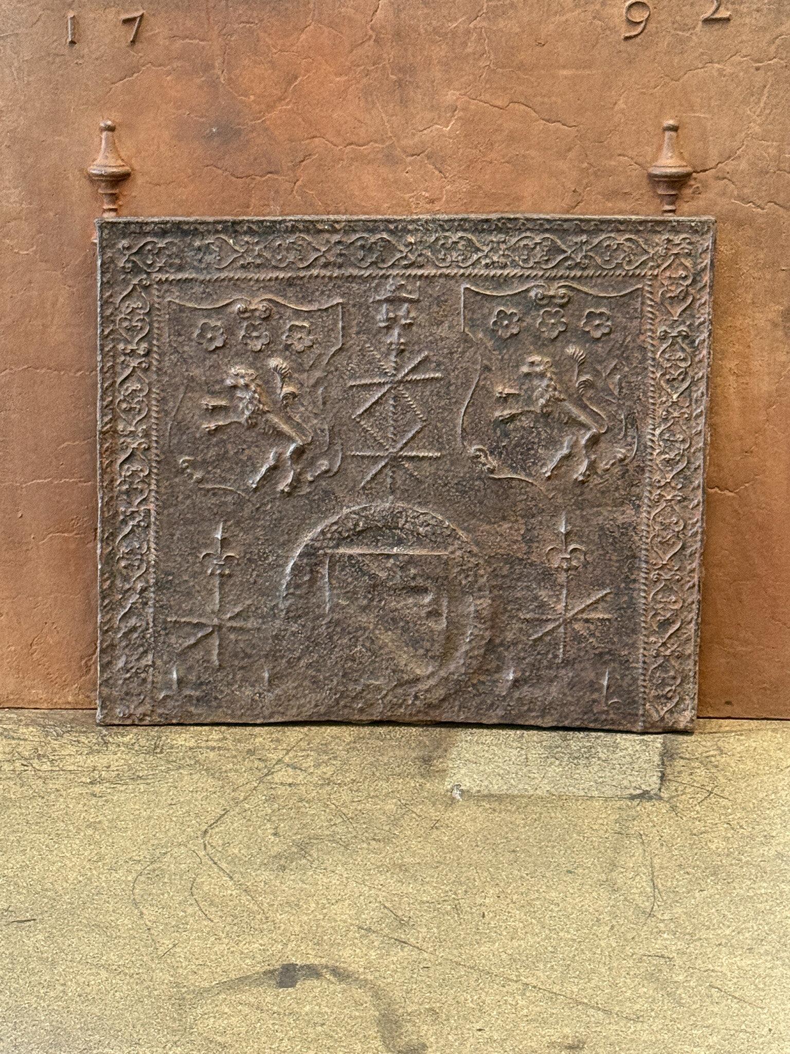 This 16th-century French Gothic fireback features an unknown coat of arms. The fireback is made of cast iron and has a brown patina. Upon request, it can be made black/pewter colored with stove polish at no extra cost. The fireback is in good