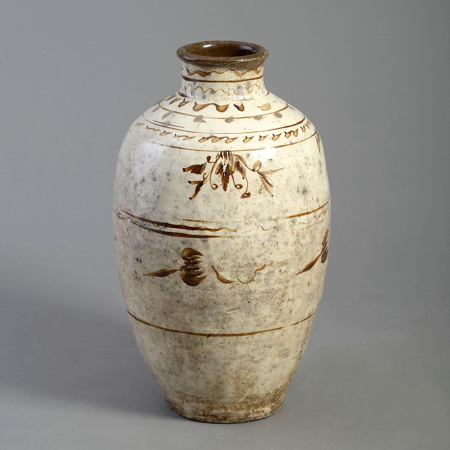 A large scale early sixteenth century Ming Period Cizhou pottery vase, decorated in the traditional manner with caramel glazes upon a cream ground.