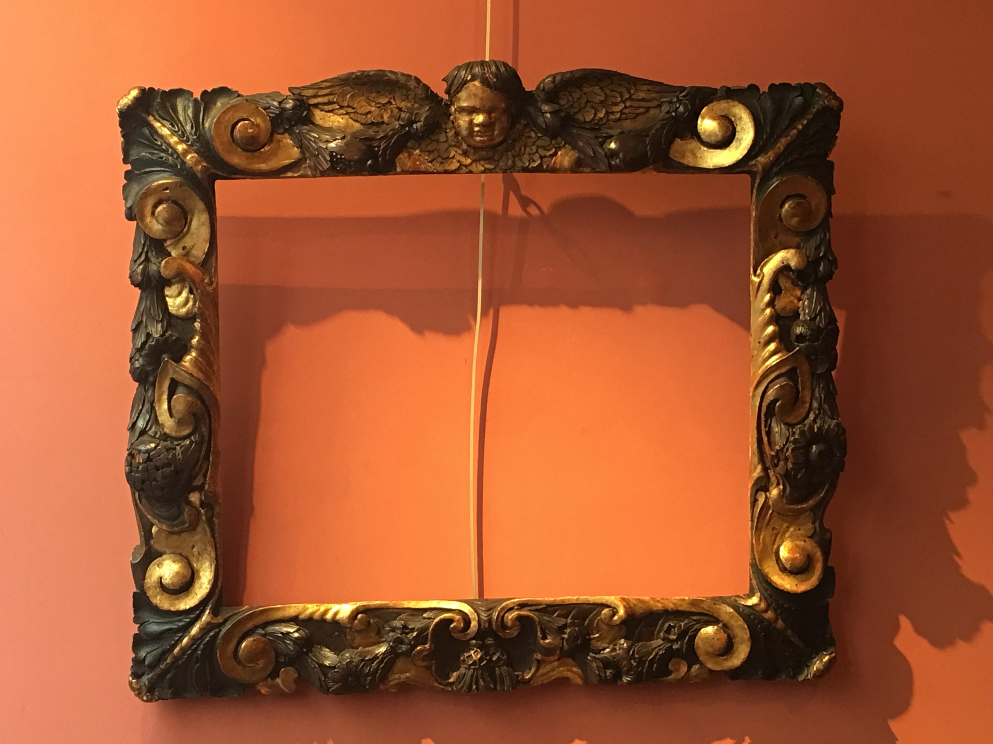 This rare Venetian frame entirely carved in high-relief shows a rich decor of scrolls, garlands, daisy flowers and thistles. At the four corners of the frame are depicted large acanthus leaves.

The upper part is centered by the head of a putto on