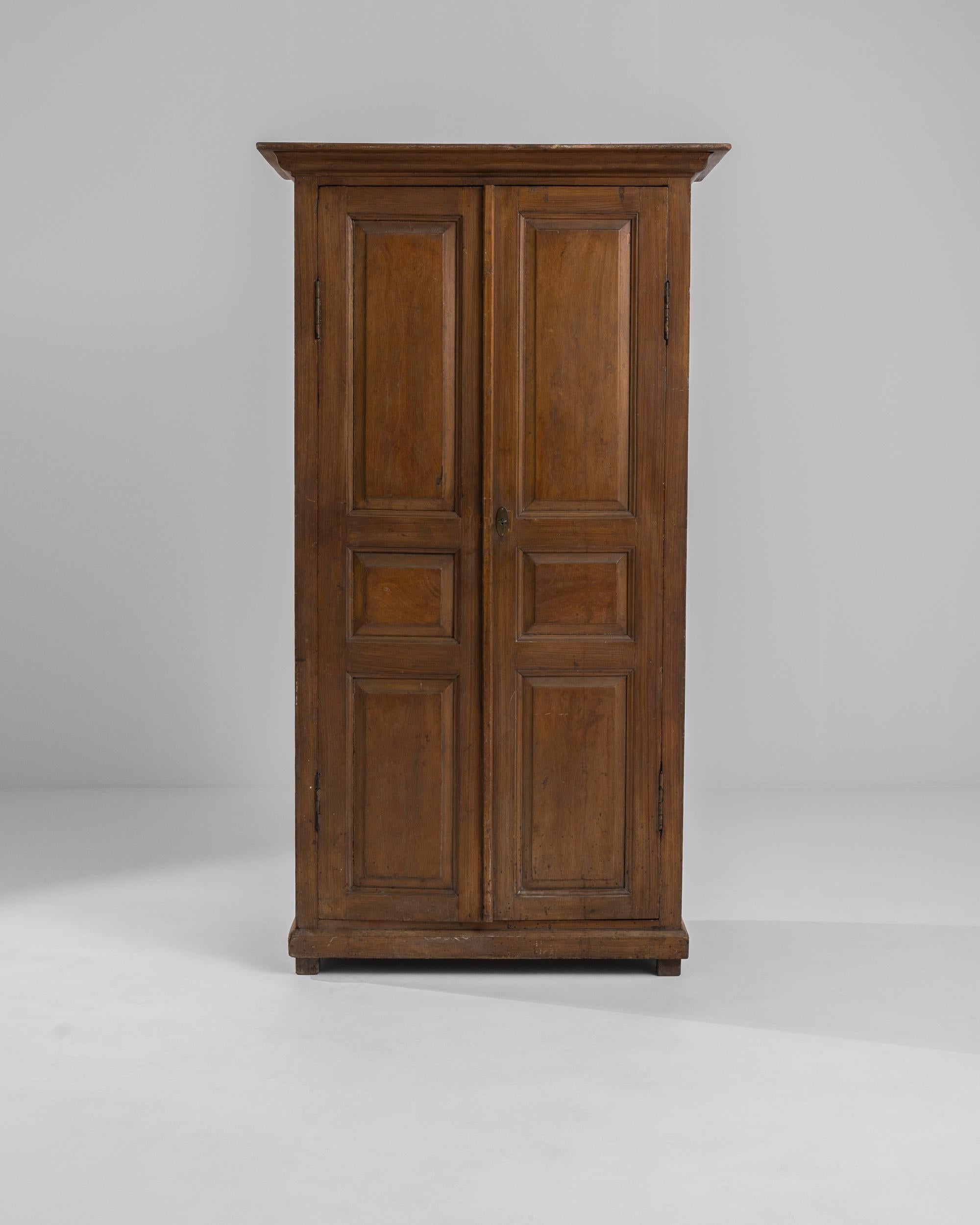 Handsome and dignified, this antique Provincial cabinet combines understated simplicity with a beautiful auburn finish. Made in Portugal in the 16th century, paneled doors unlock with a small brass key to reveal a series of spacious shelves. The