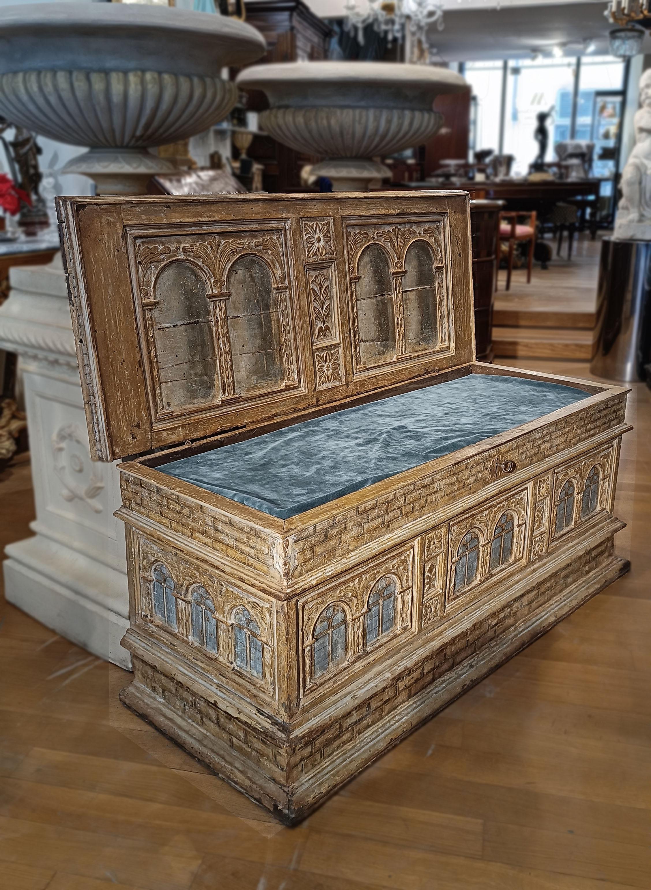 This Renaissance chest is made of fine carved and painted walnut wood with a chalky background. The decorative motifs follow the model of the prestigious Palazzo Strozzi in Florence, and give an atmosphere of elegance and refinement to the
