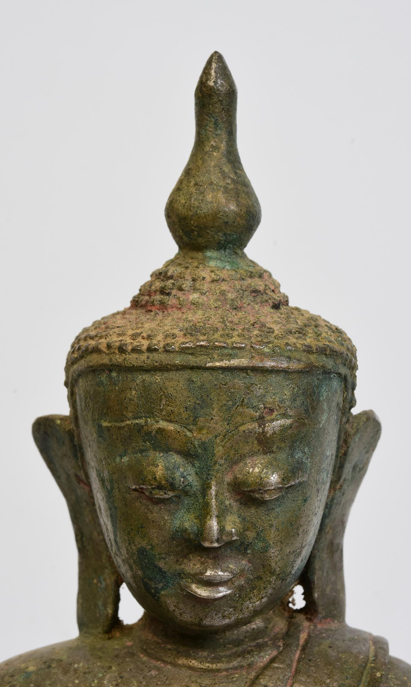 Antique Burmese bronze Buddha sitting in Mara Vijaya (calling the earth to witness) posture on double lotus base.

Age: Burma, Shan Period, 16th Century
Size: Height 31.7 C.M. / Width 18.6 C.M. / Depth 13 C.M.
Condition: Nice condition overall (some