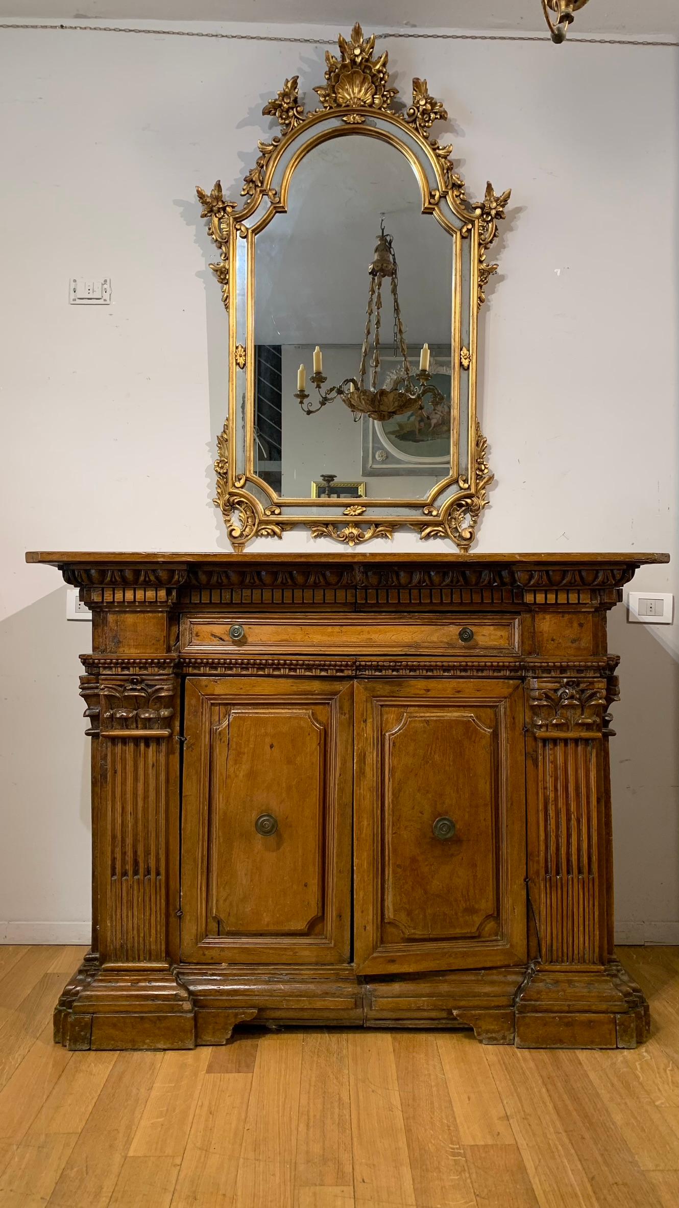 Beautiful sideboard in blond walnut from the Renaissance period, with classic architectural elements in solid walnut. The corners are decorated with pilasters and Corinthian capitals. The undertop is decorated with classic ovules. The sideboard also