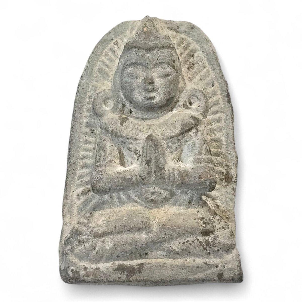Petite plaque de dévotion en pierre finement sculptée, datant probablement du XVIe siècle, représentant un Bouddha assis et serein dans une posture méditative, les mains en Anjali Mudra (geste de révérence). Cette sculpture compacte capture