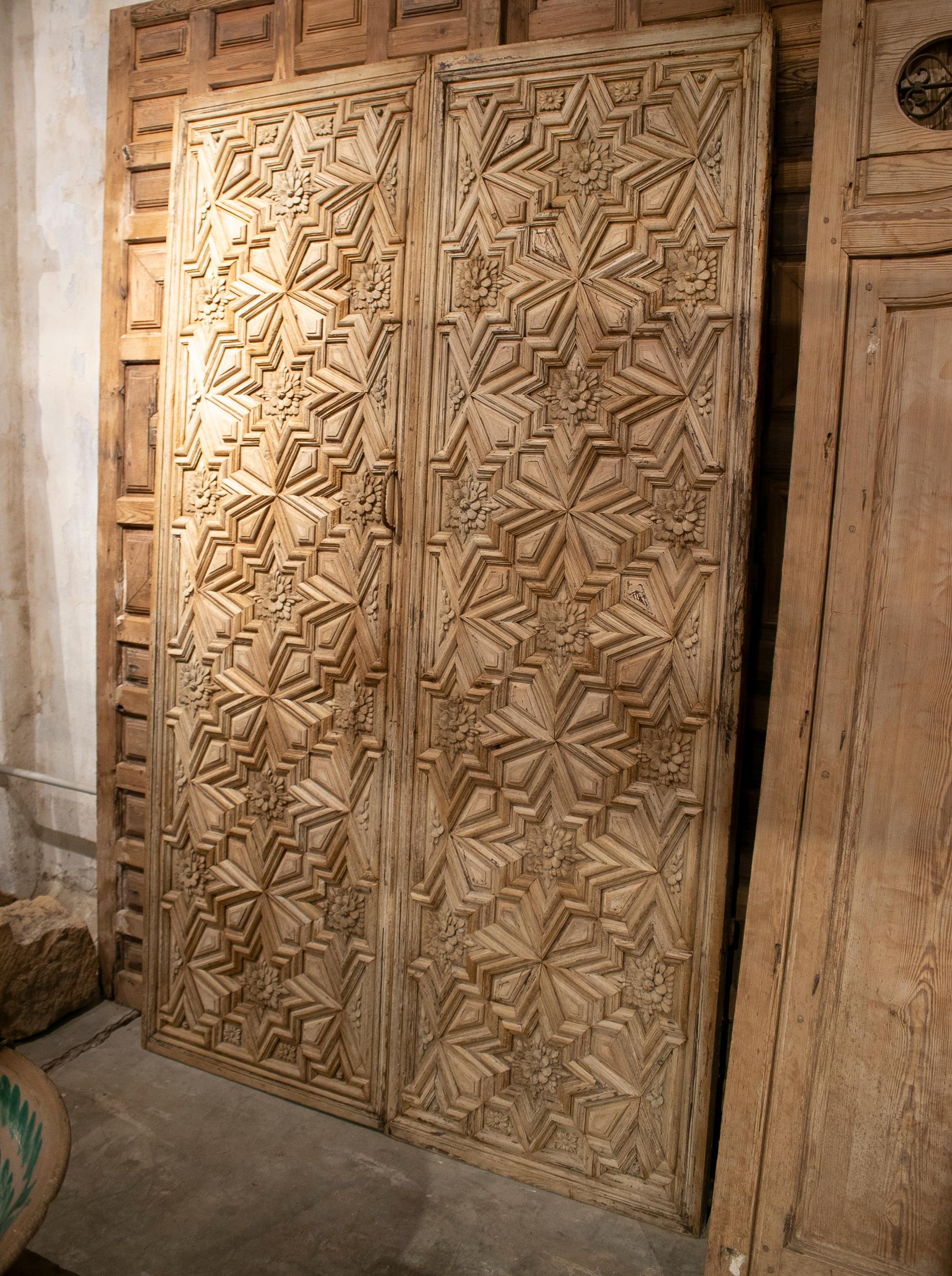16th century Spanish lime washed hand carved wooden double door with ornate geometric and plant decoration.