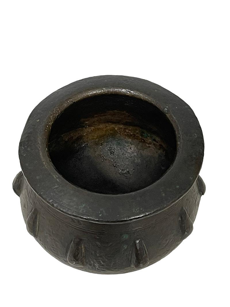 Mortaio in bronzo moresco spagnolo del XVI secolo 

Un piccolo mortaio rotondo in bronzo patinato marrone scuro, appoggiato su una base rotonda. L'esterno è decorato con un motivo a coste verticali del XVI secolo. Non è presente il pestello. 
La