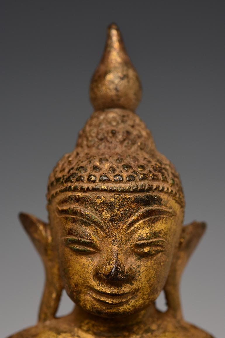 Burmese bronze Buddha sitting in Mara Vijaya (calling the earth to witness) posture on double lotus base, with gilded gold.

Age: Burma, Shan Period, 16th Century
Size: Height 21.8 C.M. / Width 11.3 C.M.
Condition: Nice condition overall (some