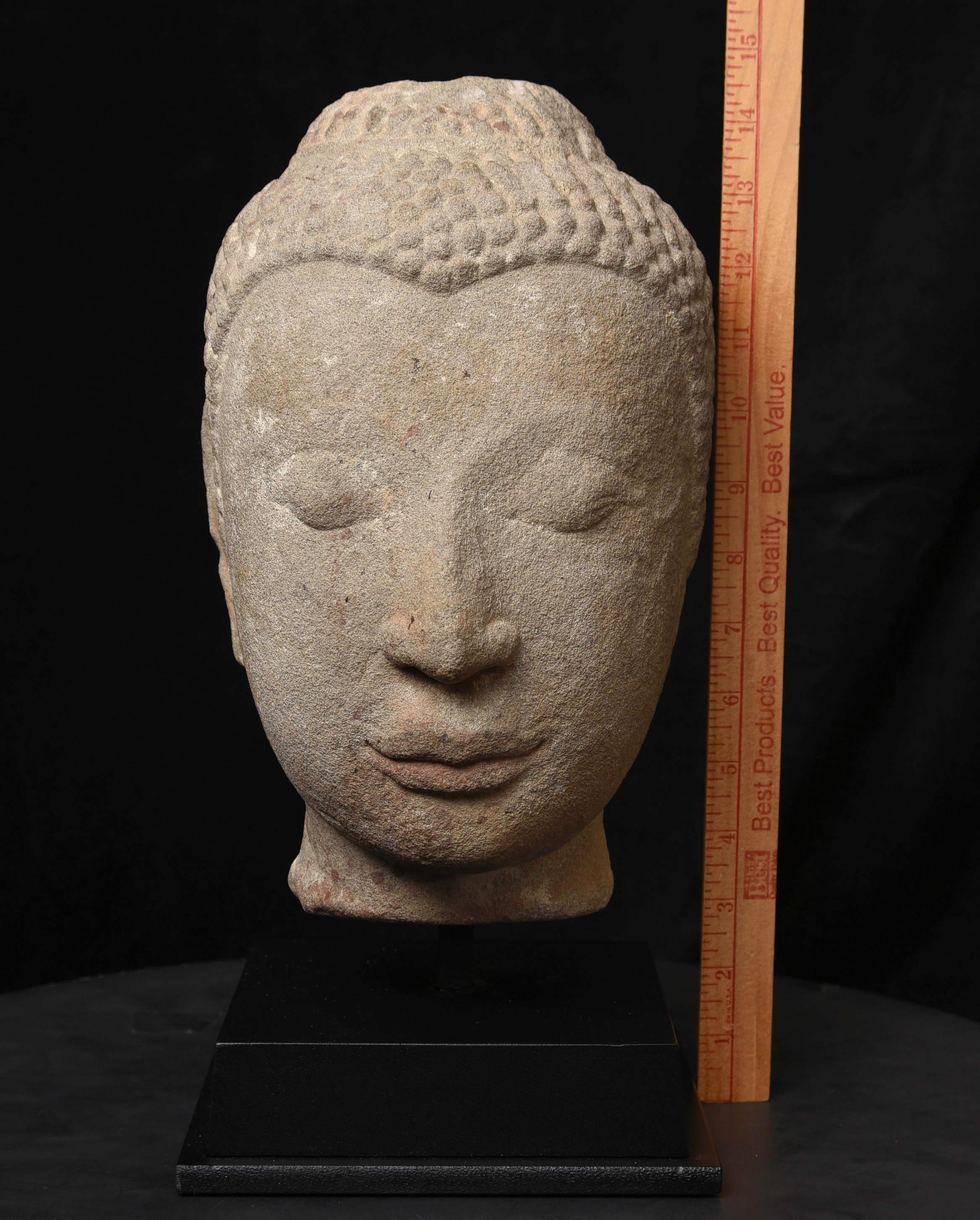 Life-size 16th century Thai stone head. The face is absolutely classic for this type--powerful, kind, and calm. The condition is very good, as can be seen in the photos. Large Buddhas of this type were meant to be looked at from below, as this