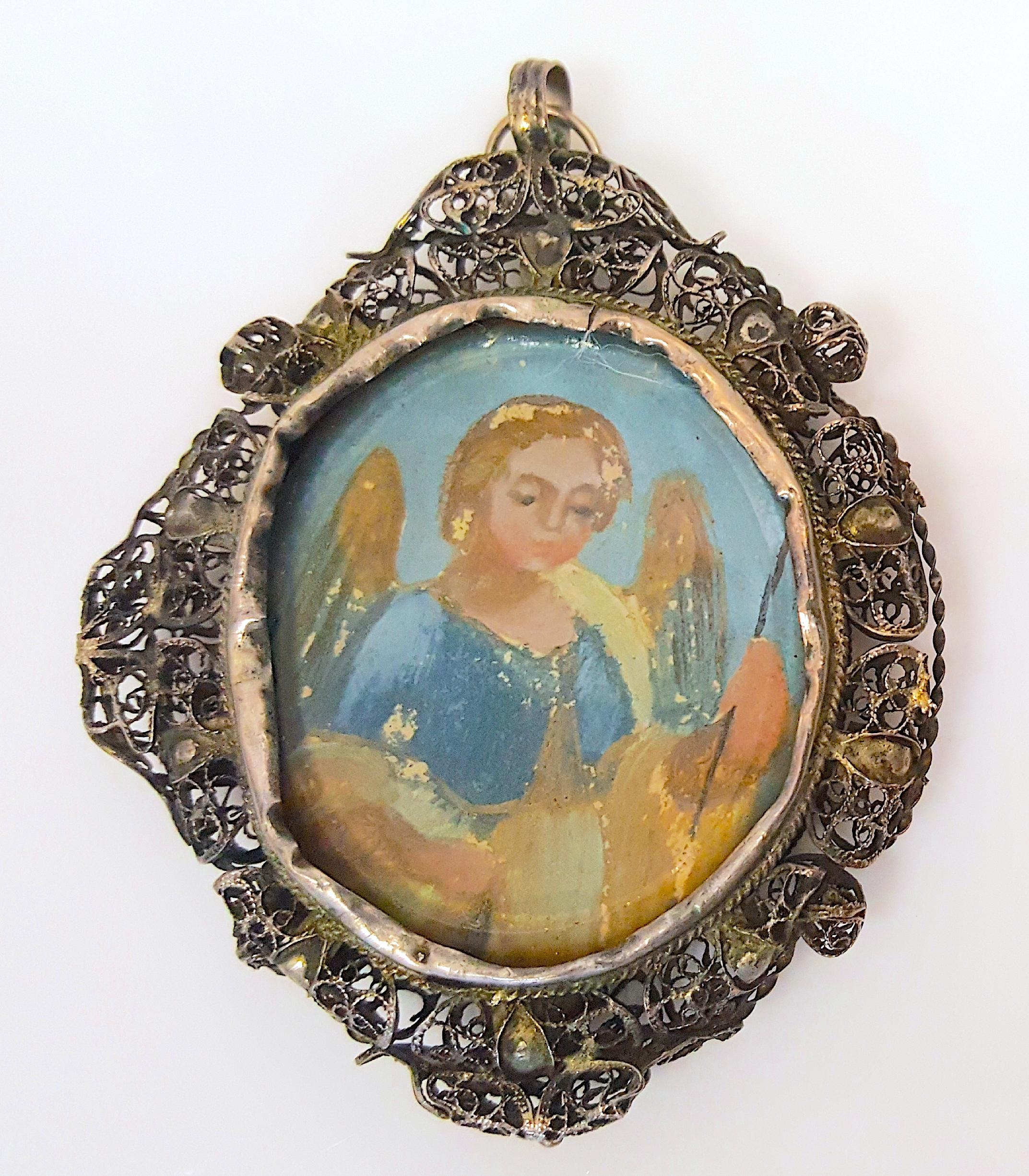 With artistic value as a Renaissance chiaroscuro painting, this early 16th-Century period gilt silver-filigree pendant medallion encases a colorful figure of the upper body of a winged angel with a staff in its left hand, which is protected by a