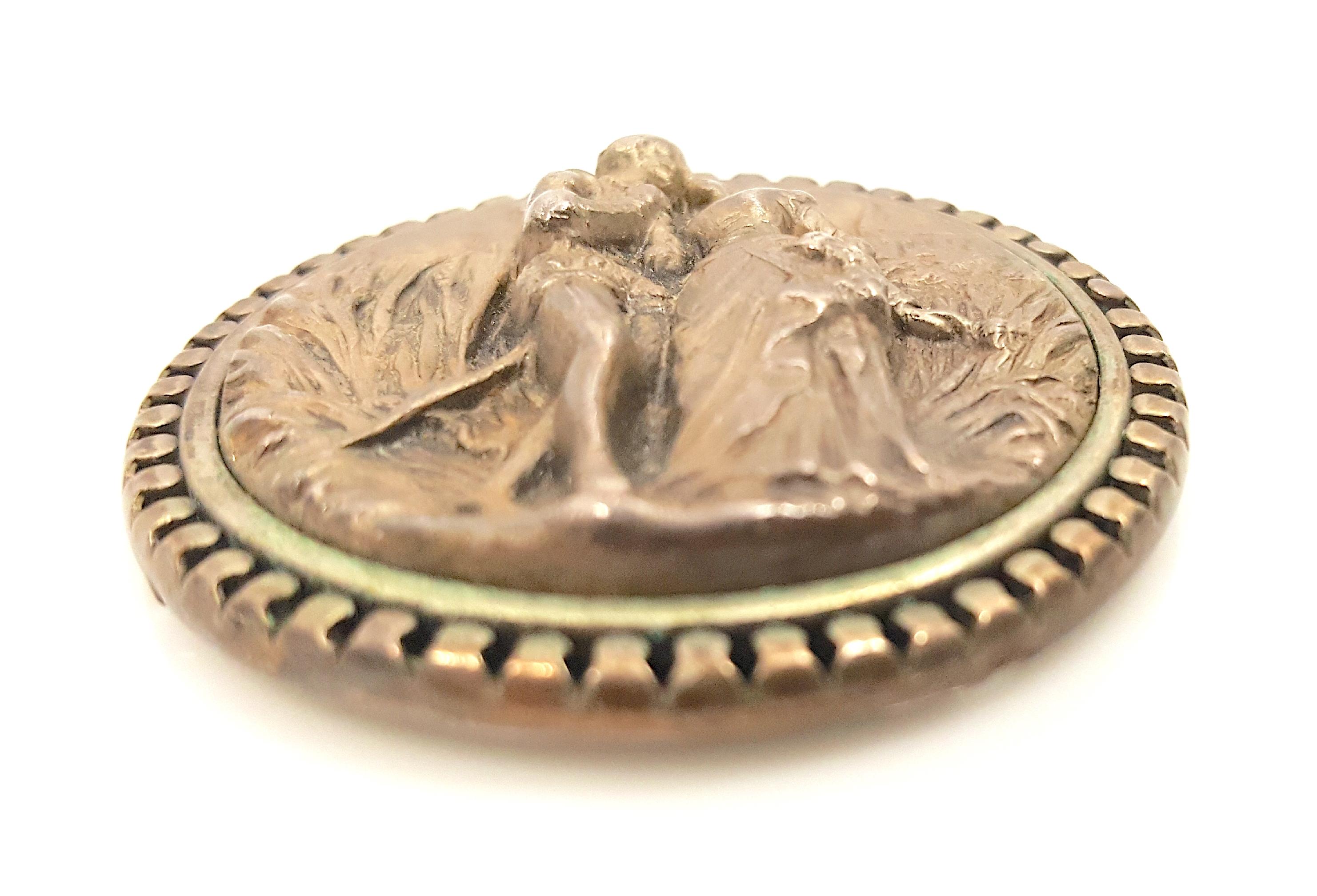 Ce pendentif médaillon rond en argent repoussé de la Renaissance du début du XVIe siècle représente une rencontre romantique dans un paysage rural entre un homme et une femme souriante portant des vêtements de la noblesse européenne, notamment un