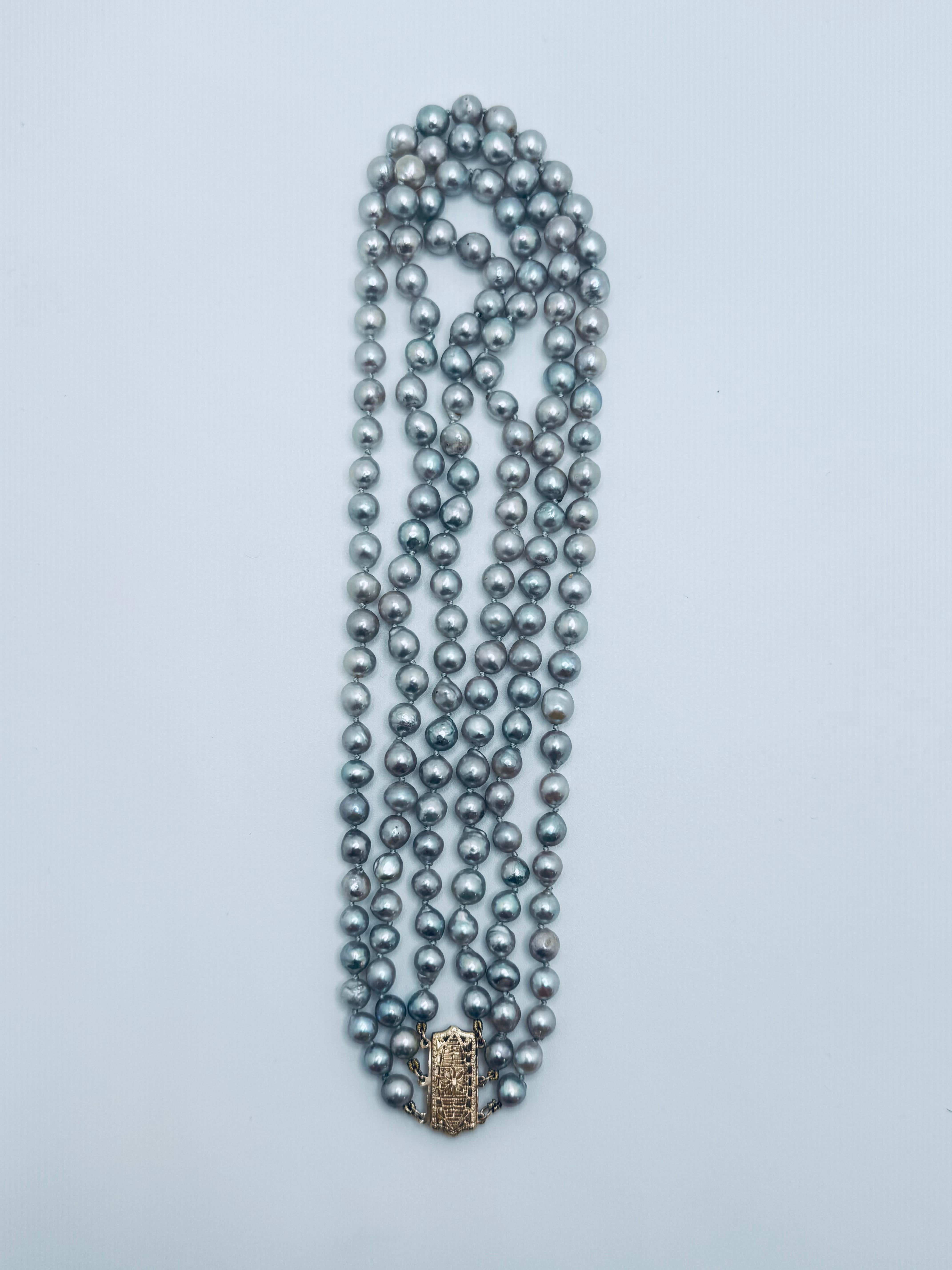 This striking 17-inch baroque grey pearl necklace showcases 159 uniquely shaped pearls in a graduated size arrangement, creating a natural, organic look. Each pearl is individually knotted for added security and a smooth, elegant drape. The baroque