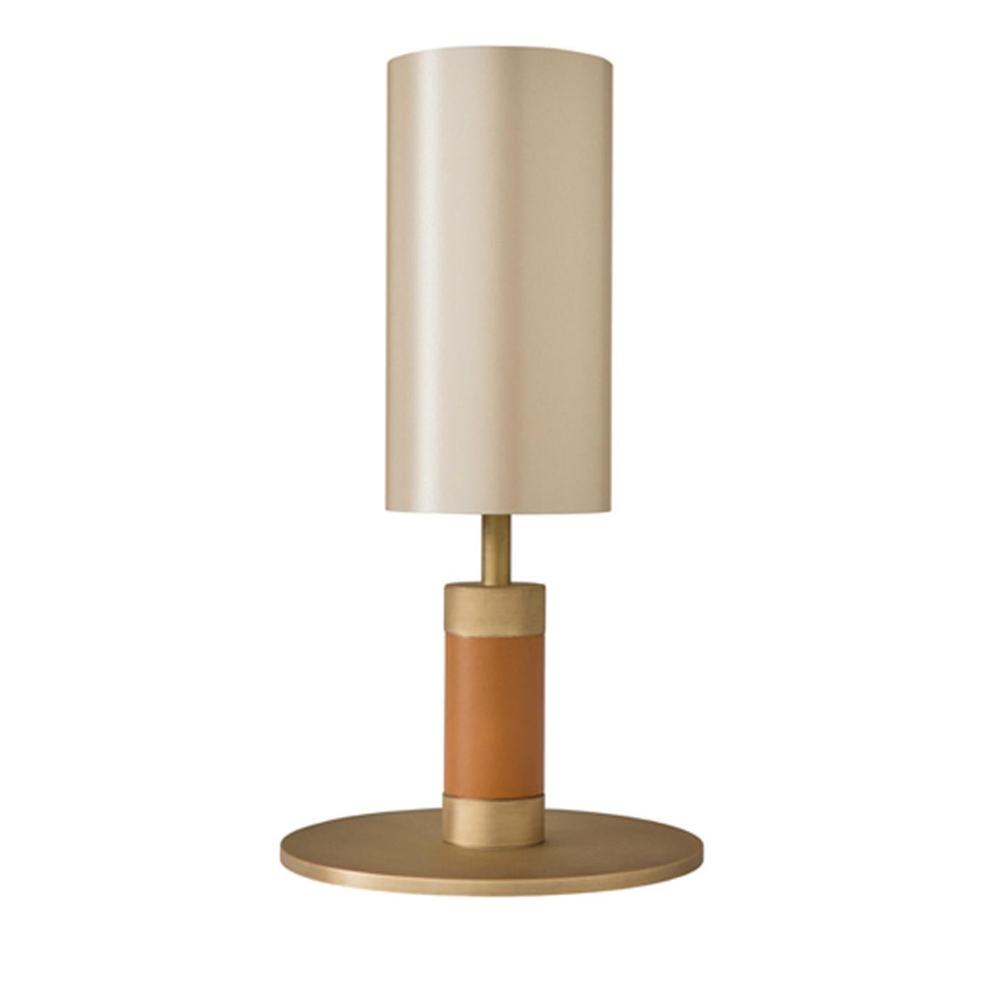 Exuding cozy, clean elegance, the 1.7 bedside table lamp is crafted in brass with a burnished finish and cognac leather and topped with a silk-effect shade. Perfect for warming up a Minimalist bedroom, the lamp comes from a complete collection of