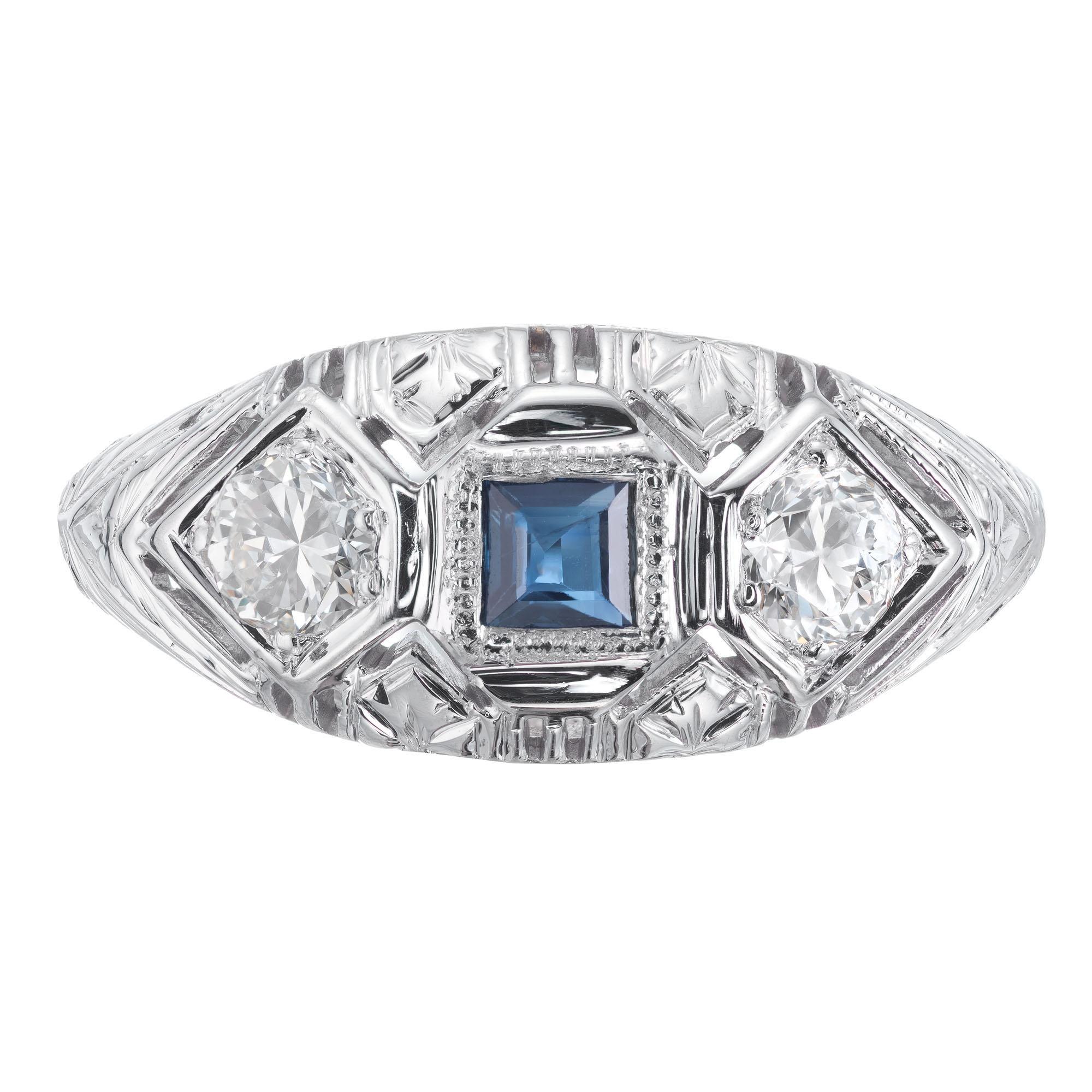 Classic 1930’s art deco square sapphire round diamond engraved and filigree ring in 18k white gold.  

1 square blue sapphire SI, approx. .17ct
2 round brilliant cut diamonds G VS, approx. .32ct
Size 6.75 and sizable 
18k white gold 
Tested: 18k
3.2