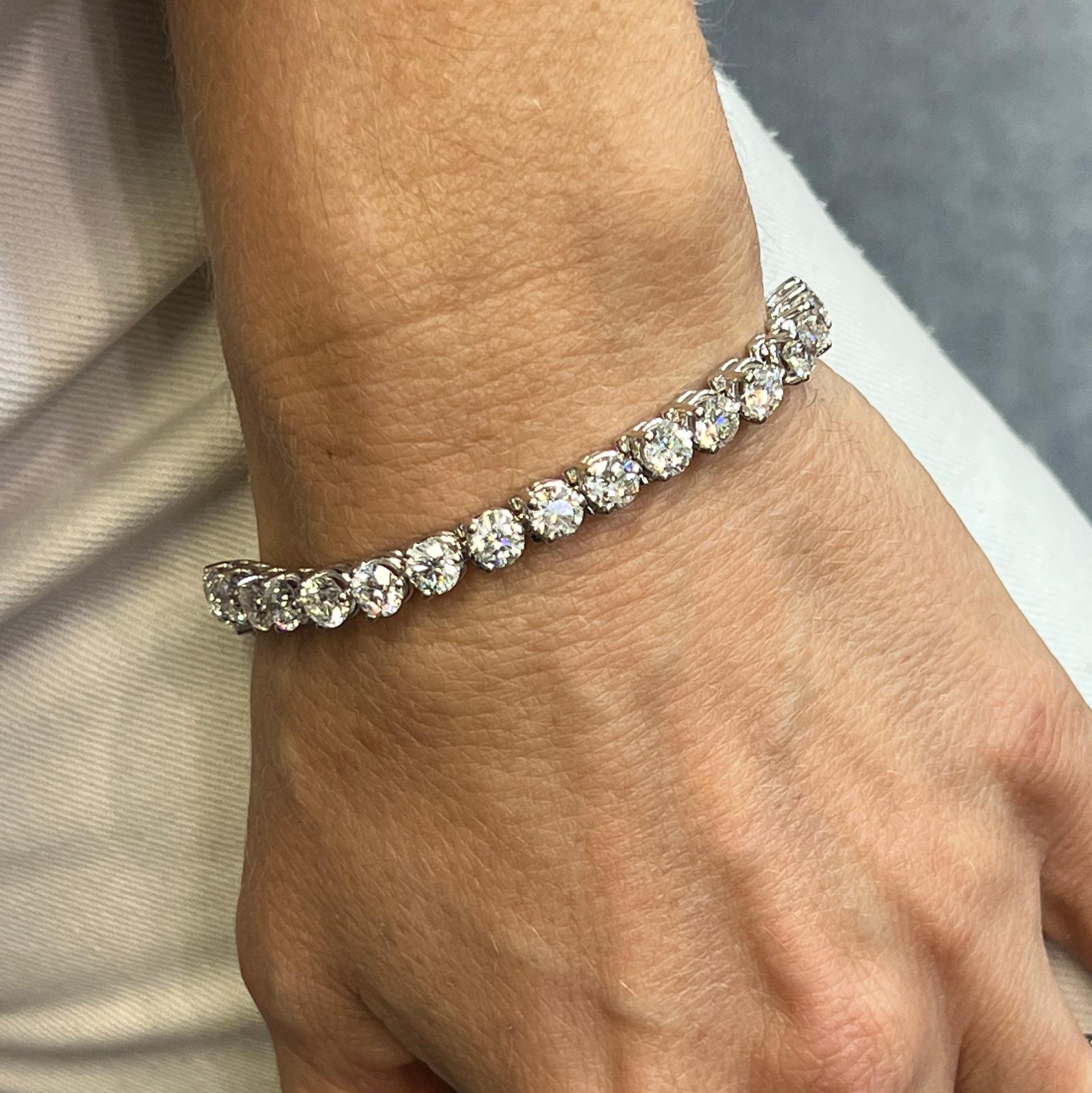 Impressive diamond tennis bracelet fashioned in 18 karat white gold. The bracelet features 34 round brilliant cut diamonds (each diamond weighs approximately .50 carat.) The 34 diamonds weigh 17.34 CTW and are graded E-F color and SI clarity. The