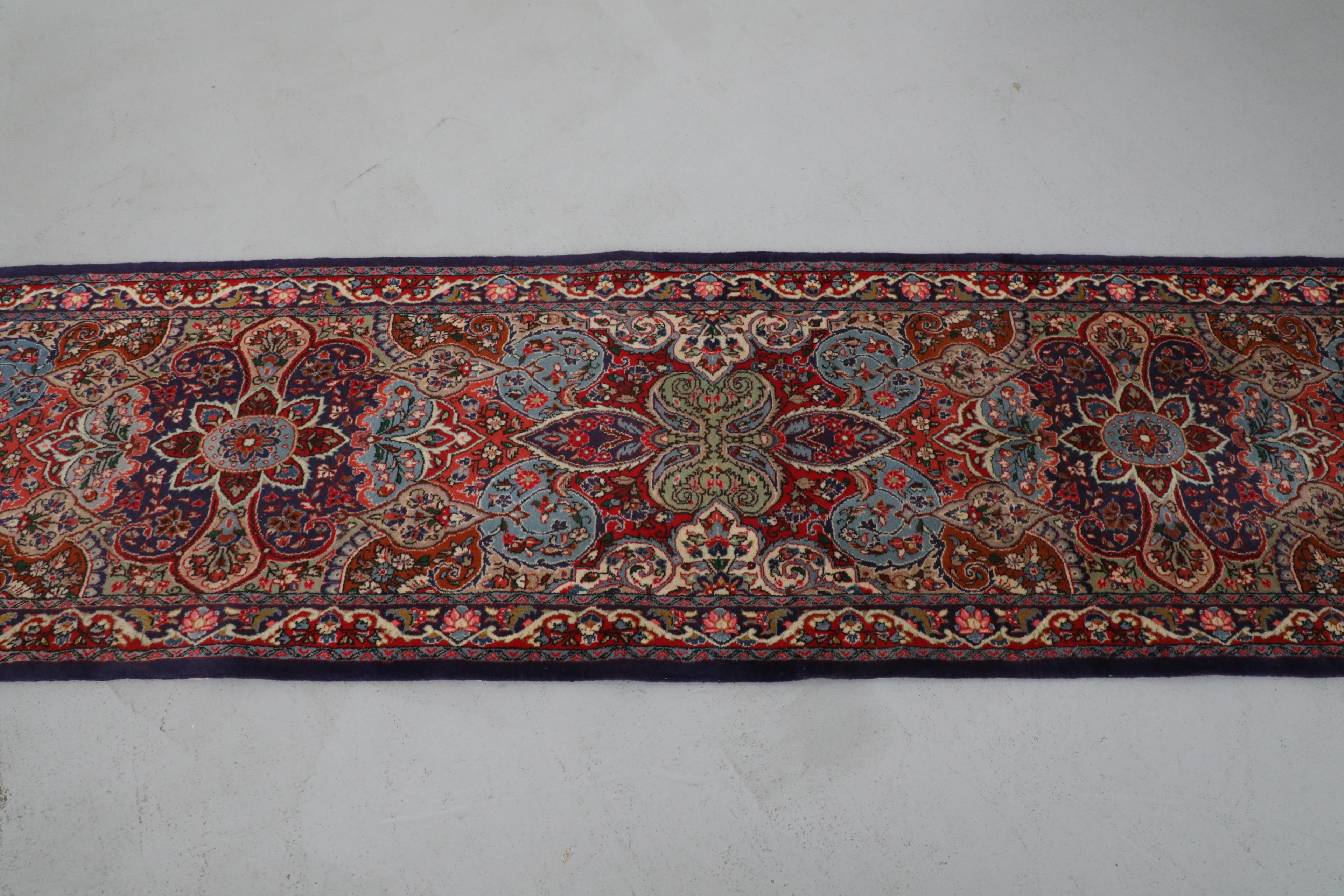 Schöner handgewebter extra langer Woll-Läufer. Dieser Teppich besticht durch aufwändige, farbenfrohe Blumenmuster in Rot-, Blau- und Rosatönen mit cremefarbenen Fransen. In gutem Originalzustand.