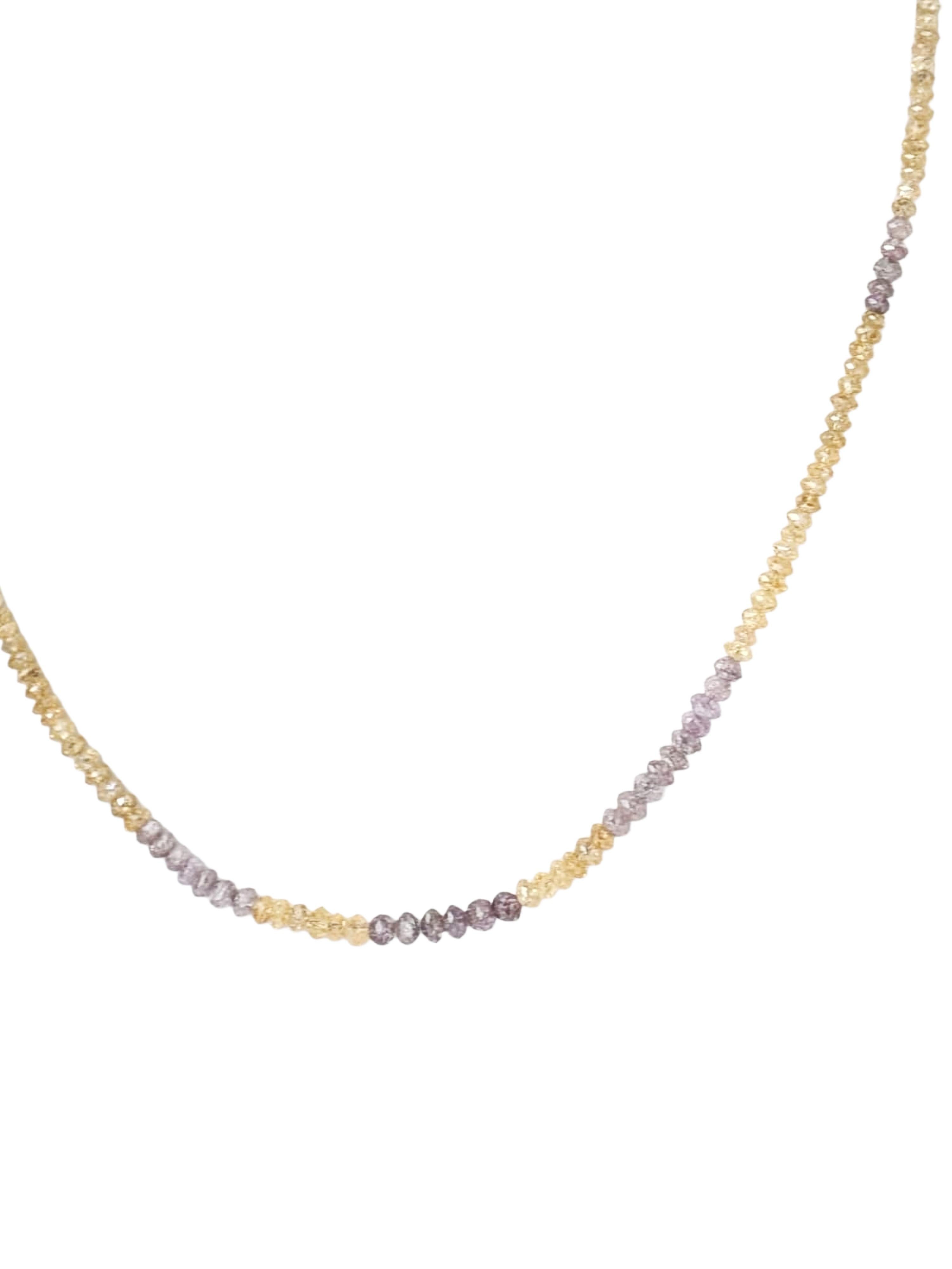 Un filo che celebra l'eleganza grezza e il calore dorato. Questa collana presenta perle di diamante rotonde sfaccettate di colore giallo e viola, ognuna con inclusioni uniche e un bagliore tenue che aggiunge profondità e carattere. Legato a mano e