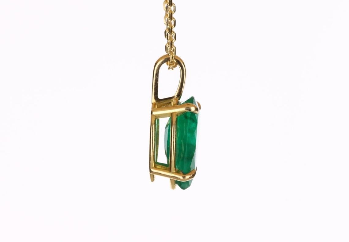 Displayed is a classic Colombian emerald solitaire necklace set in 18K yellow gold. This gorgeous solitaire pendant carries a full 1.70-carat emerald in a four-prong claw setting. Fully faceted, this gemstone showcases excellent shine. The emerald