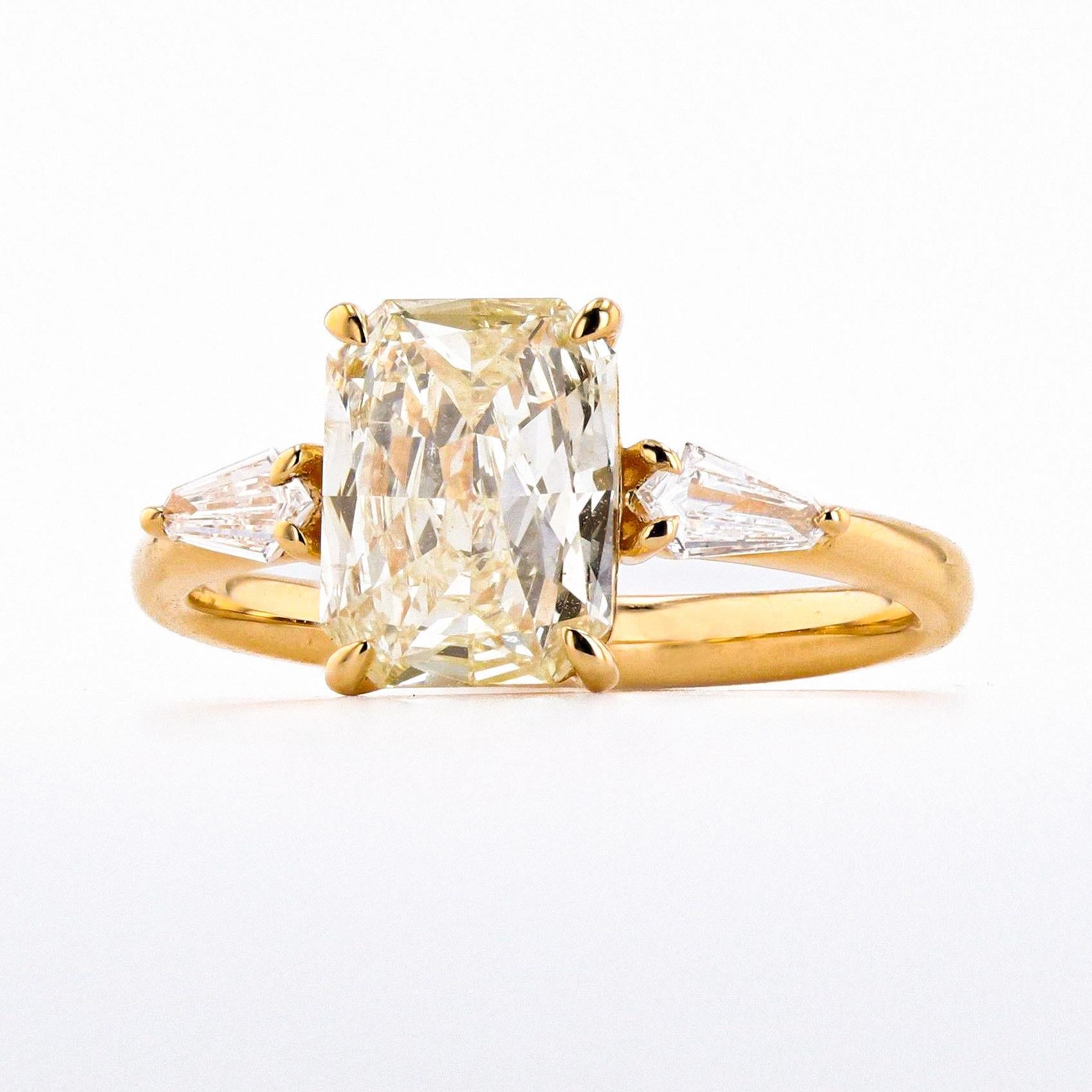 Introducing a breathtaking ring featuring a stunning 1.70 carat champagne diamond and two elegant .18 carat shield cut side stones. This piece is a true masterpiece, with a unique and alluring color that is sure to captivate anyone who appreciates