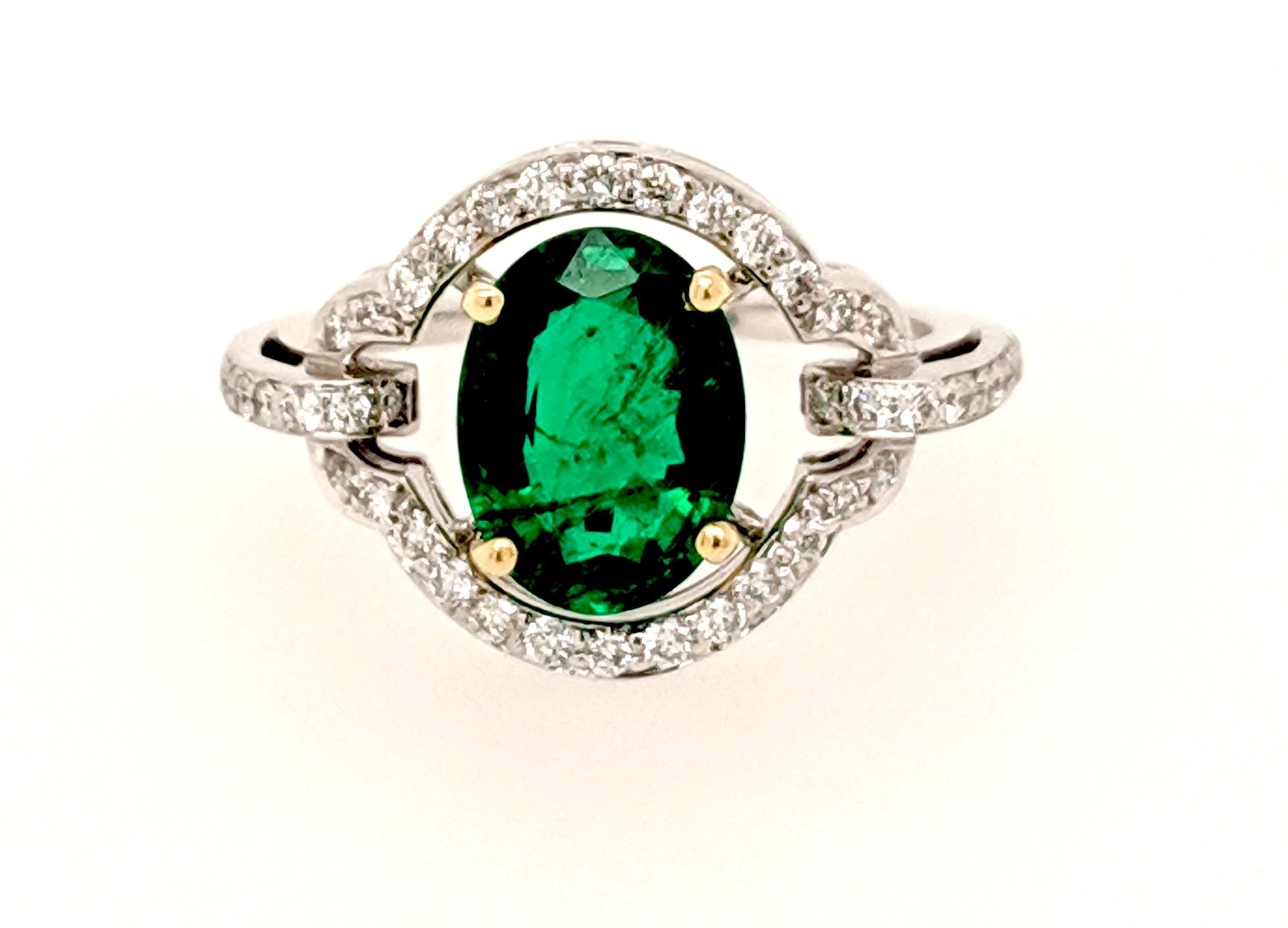 The Cocktail ring is crafted in 18k white and yellow gold featuring (1) oval shaped emerald weighing 1.70ct of African origin and surrounded by (48) round diamonds weighing .34cttw with a color of G/H and a clarity of VS2 to SI1. The ring is a size