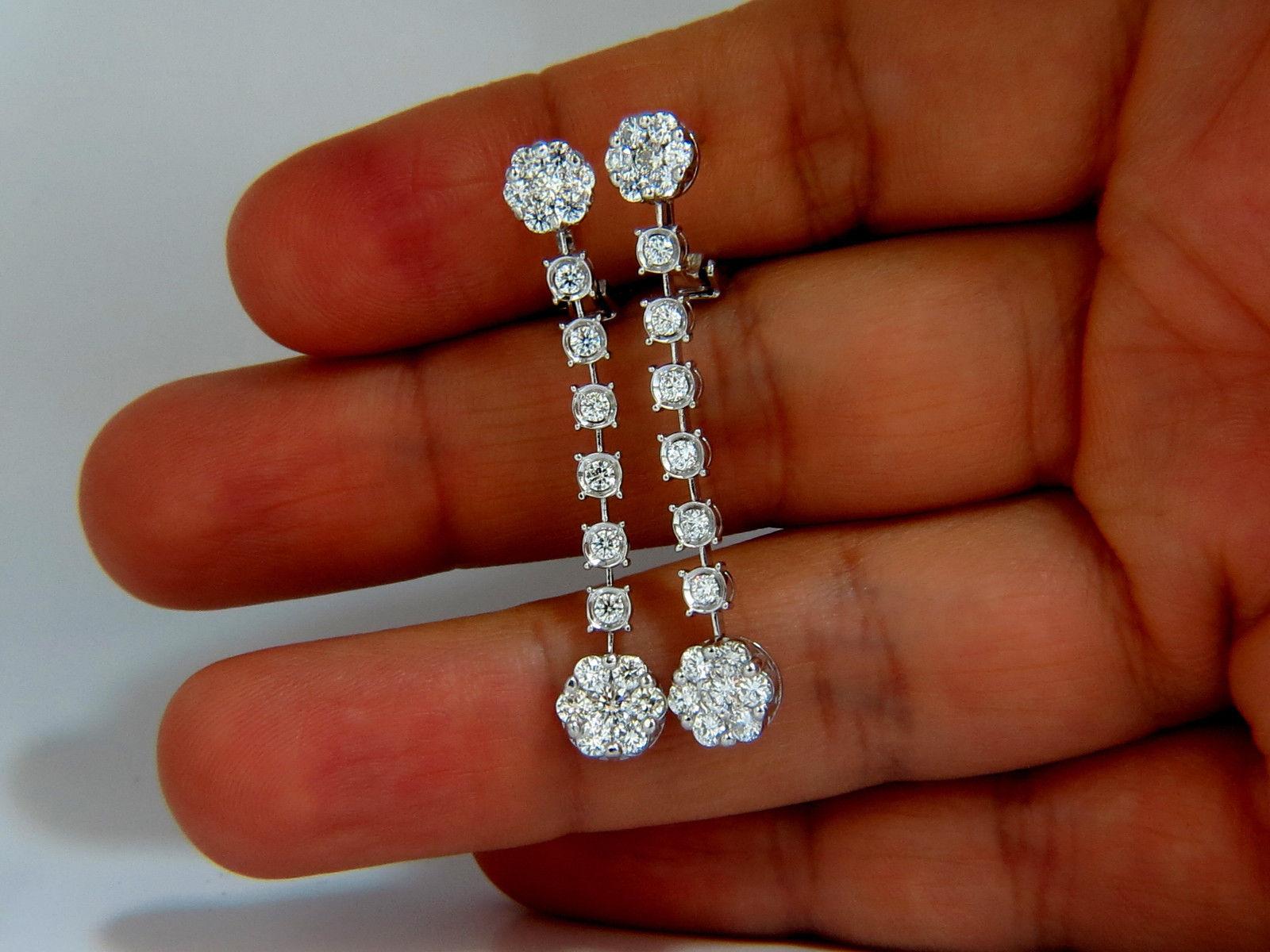 Floating, rounds double clustered dangle earrings.

The Edwardian Revival.

1.70cts of natural round diamonds: 

G-color, Vs-2 clarity.

14kt. white gold

6.9 grams.

Earrings measure: 43.5mm long (1.7 Inch)

7.5mm (.29 inch) diameter on lower