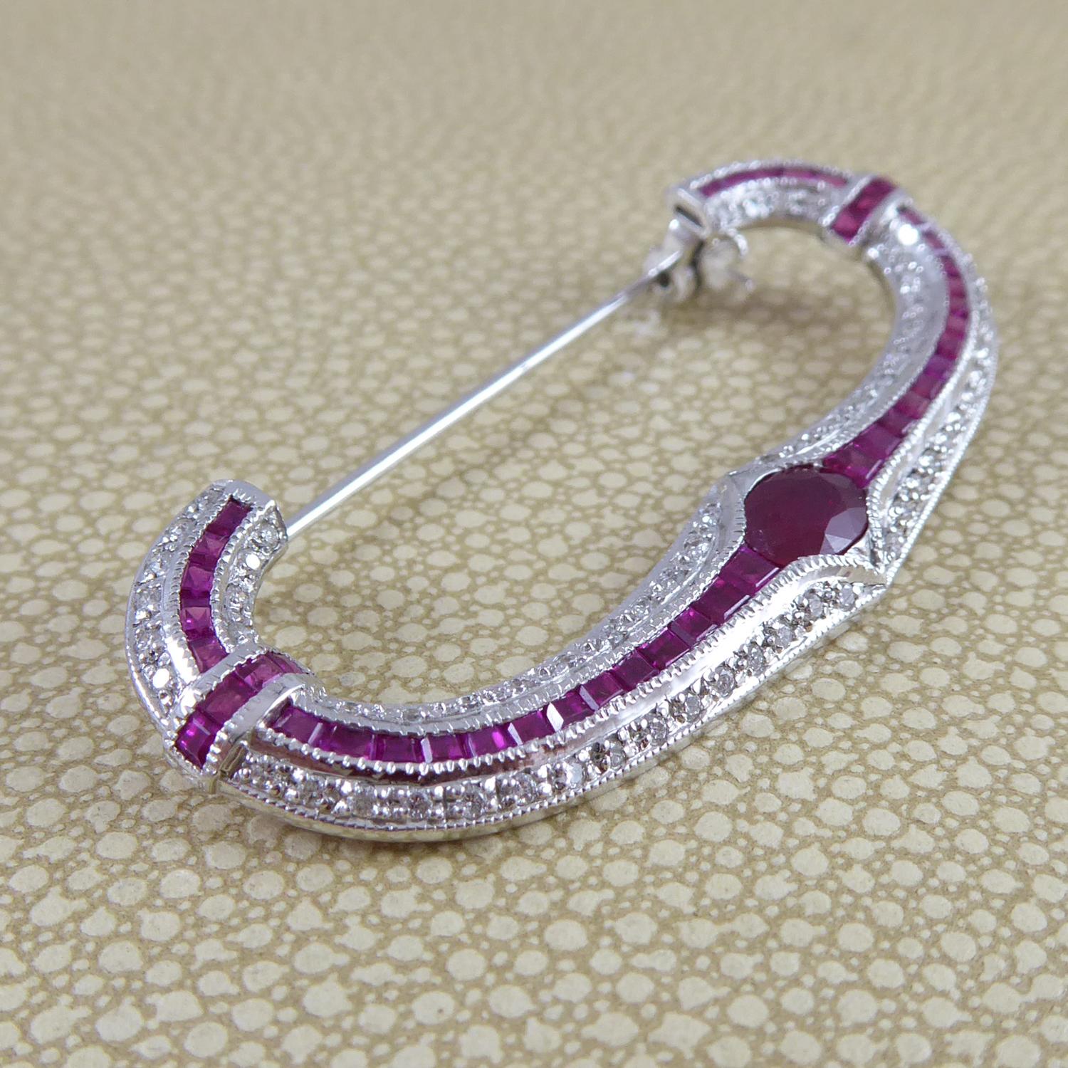 A modern gem set brooch featuring a curved panel set with a principal oval shaped, mixed cut ruby, measuring approx. 6.80mm x 4.80mm x 2.50mm deep, tension set and flanked to each side by approx. 22 graduating calibre cut rubies which measure from