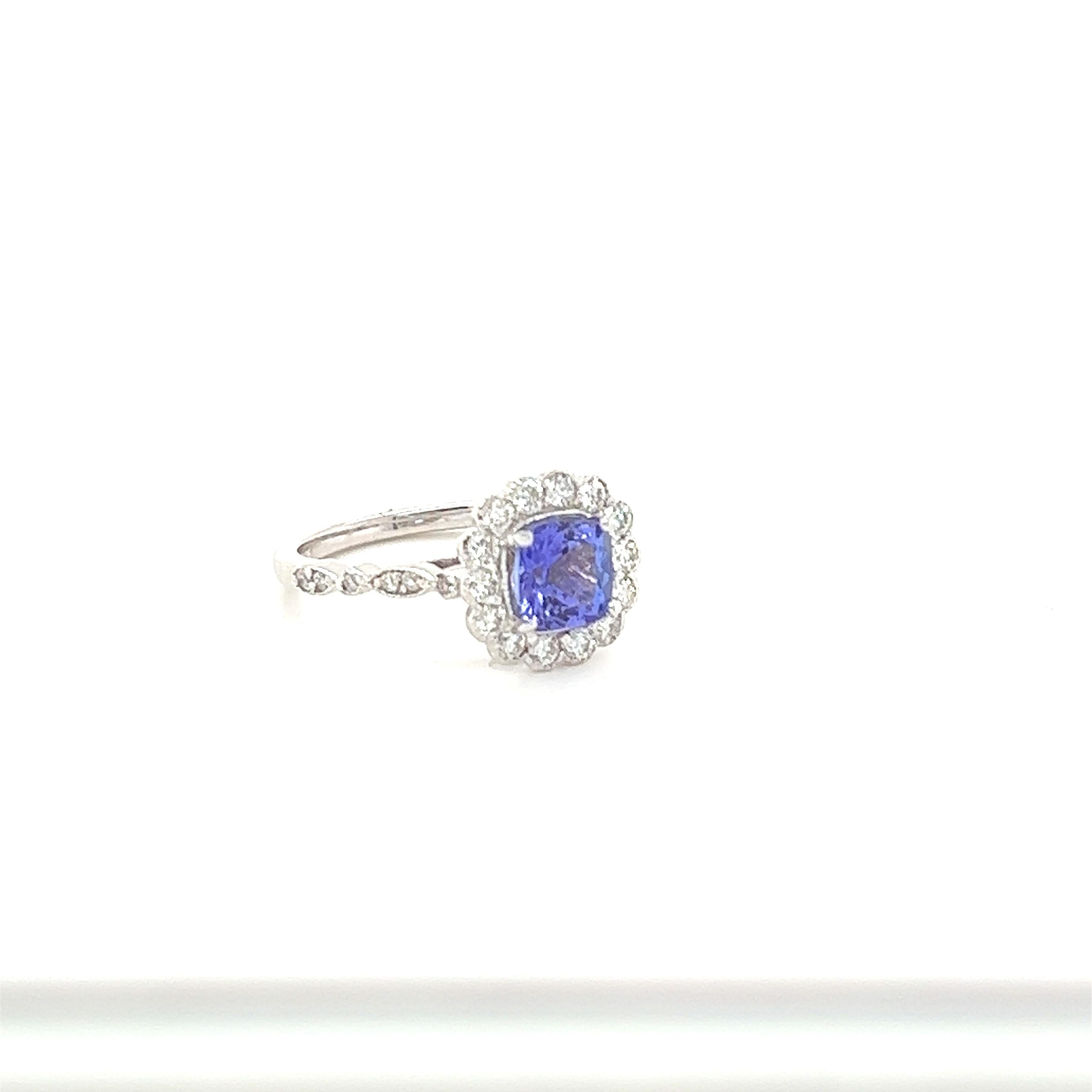 This beautiful ring has a vivid 1.26 Carat Natural Cushion Cut Tanzanite. The Tanzanite is surrounded by 26 Round Cut Diamonds that weigh 0.44 Carats. (Clarity: SI2, Color: F)  The total carat weight of the ring is 1.70 Carats.  

The ring is made