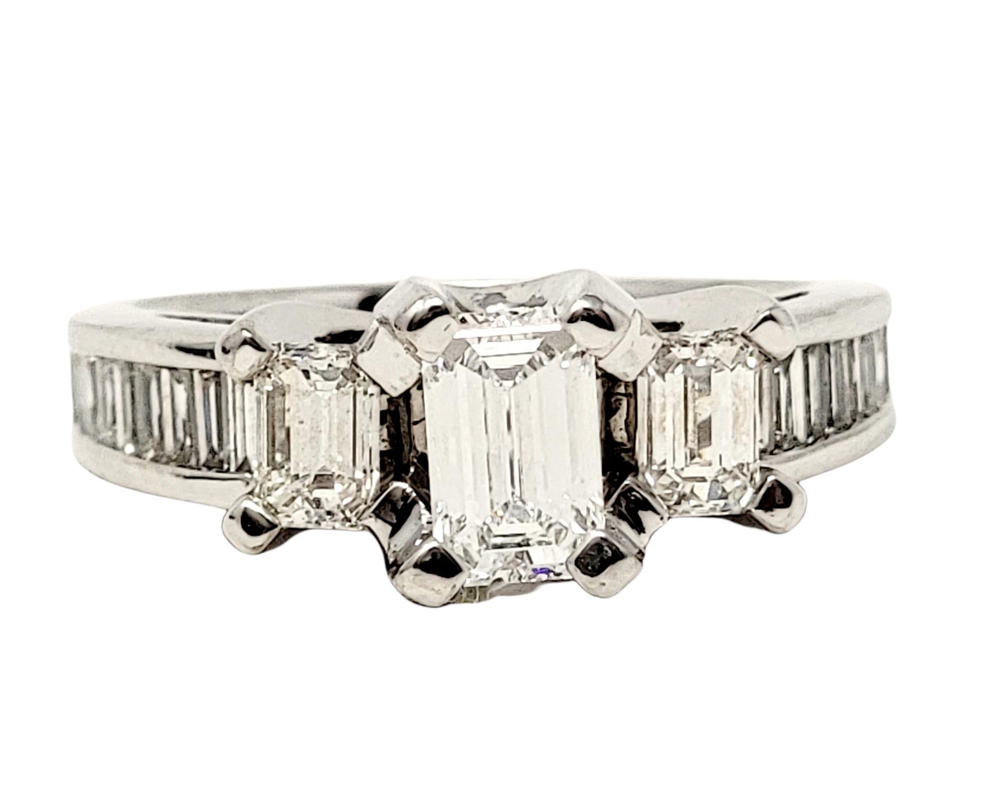 Ring size: 6.75

Absolutely gorgeous contemporary diamond engagement ring. This 3 stone beauty features a single prong set  .70 carat emerald cut diamond flanked by 2 smaller emerald cut diamonds. Along the top half of the shank are additional