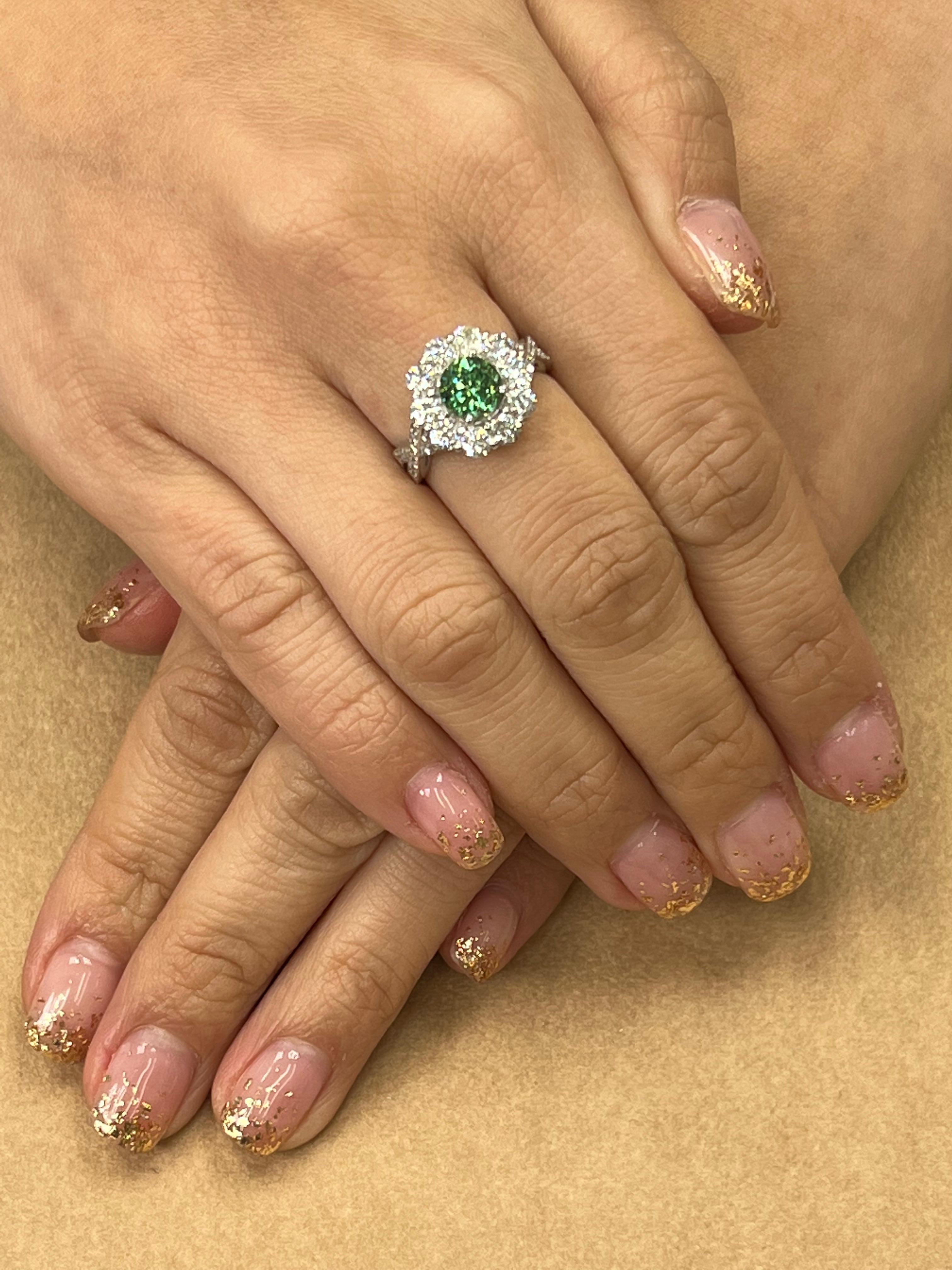 Please check out the HD video! Here is a beautiful and rare Demantoid Garnet and diamond cluster ring in the shaped of a flower. The ring is set in platinum. The center Demantoid garnet is 1.70cts. Surrounding the center stone are 10 larger diamonds