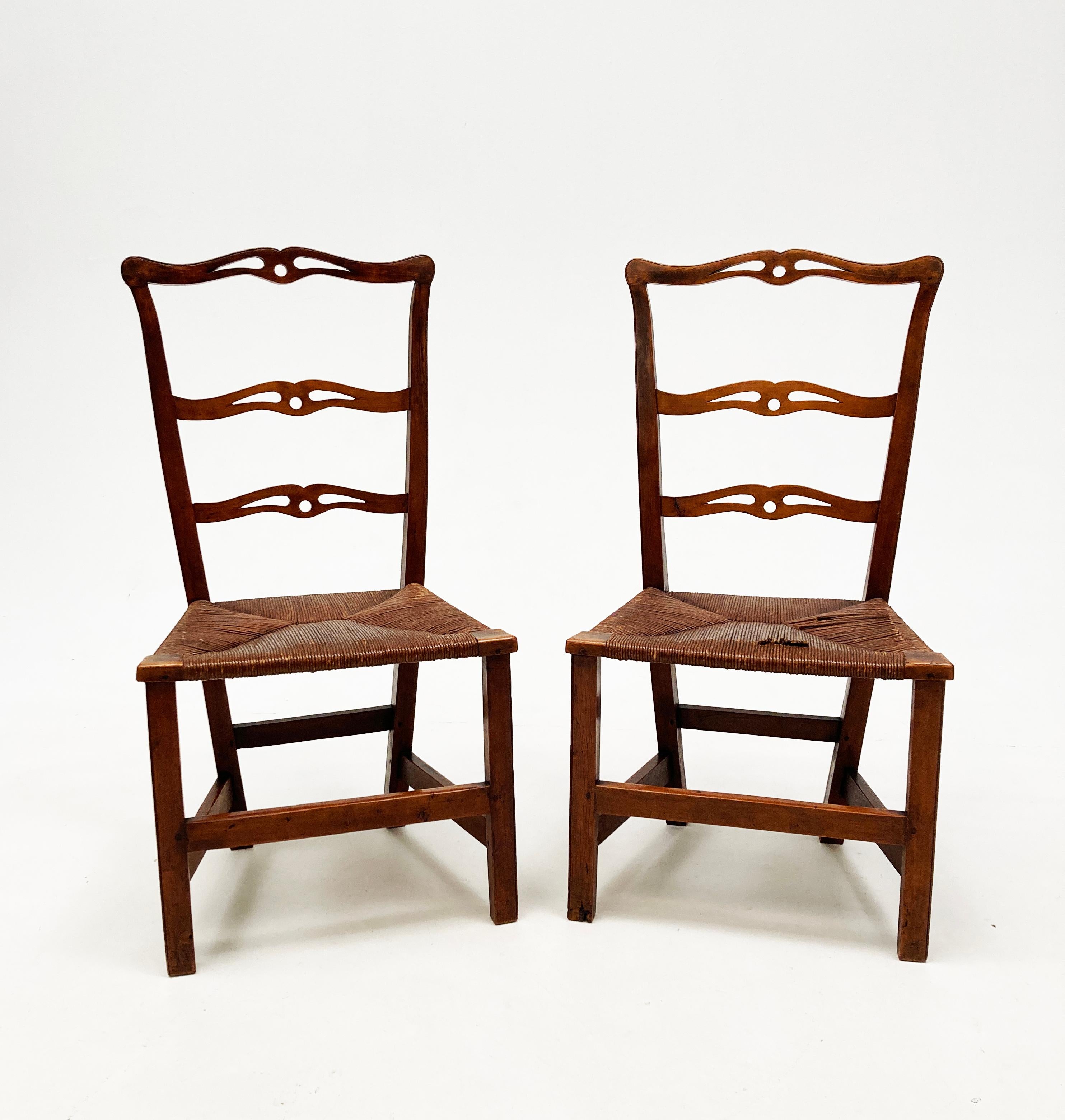 If these two chairs could speak, the history they might share. These rare and very early chairs are hand-carved and constructed in a refined primitive country design, reflective of the era. Utilizing a stunning, rich maple, the top rails and cross