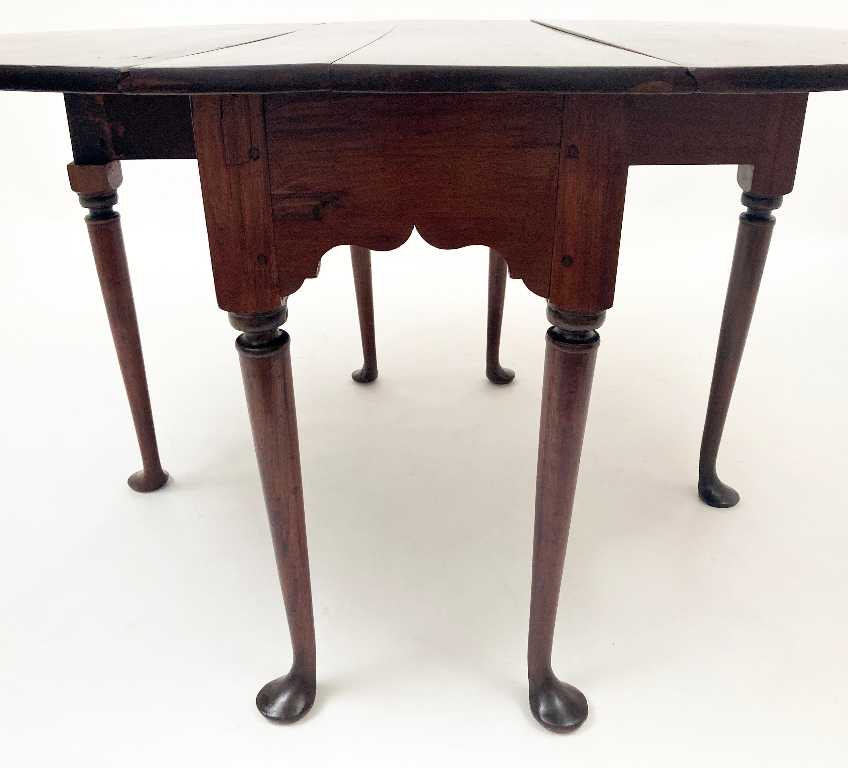 This amazing Kentucky mahogany table was hand made in the mid 1700's. Every element of this table was done by hand via carving, plane or forging. It's construction showcases wooden pegs, square nails and large hand-forged spikes to hinge the