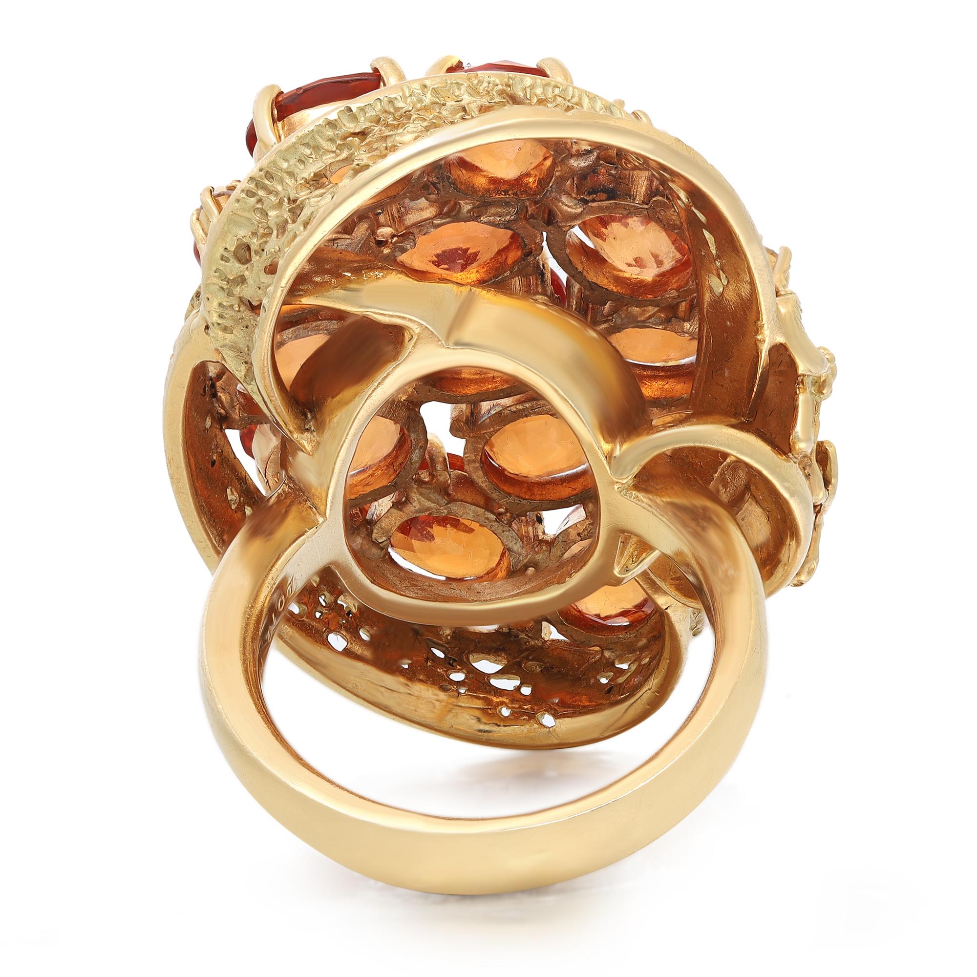 This stunning cocktail ring comes with a flashy statement look. A must have in your jewelry collection. The ring is crafted in 18K yellow gold. Features 13 prong set oval cut golden orange sapphires weighing 17.05 carats with 5 side round brilliant