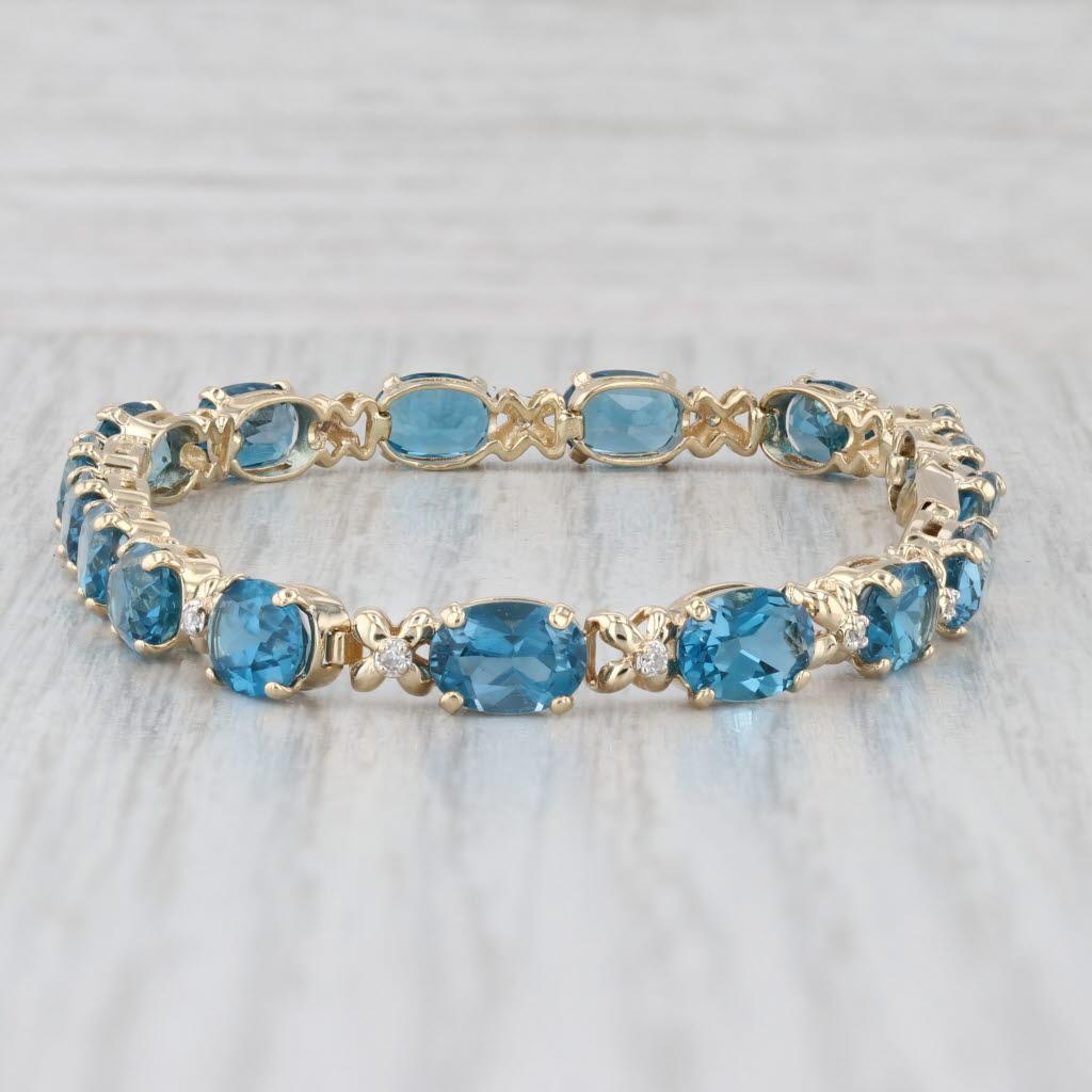 Bracciale tennis con topazio blu di Londra da 17,09 ct. in oro giallo 14 ct. con accenti di diamanti da 7
