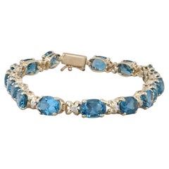 Bracciale tennis con topazio blu di Londra da 17,09 ct. in oro giallo 14 ct. con accenti di diamanti da 7".