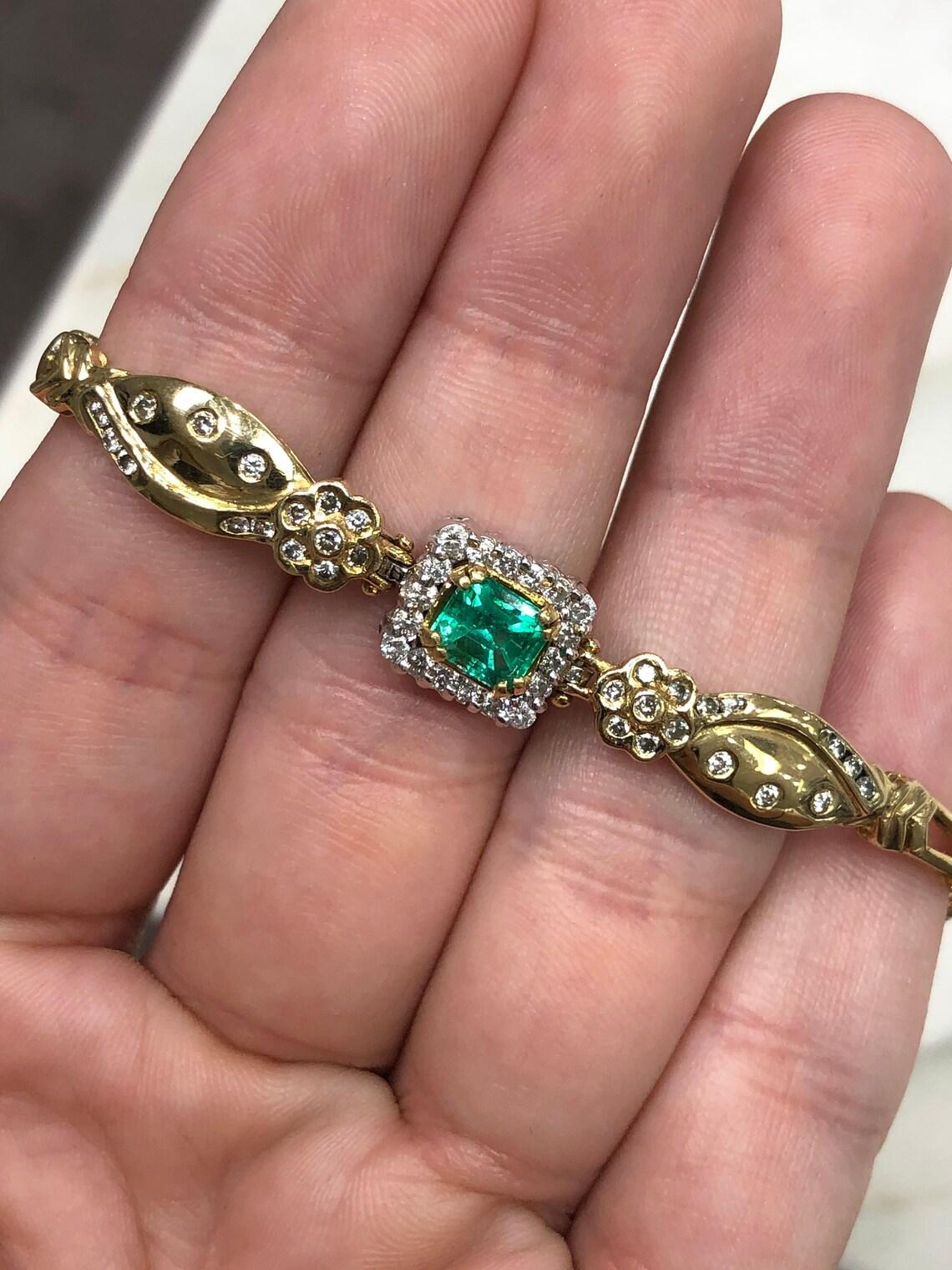 Date un capricho con una pulsera de tenis de oro con esmeralda colombiana y diamantes de 1,70 quilates. Una vivaz esmeralda verde está engastada en el centro de esta impresionante pulsera. Las pequeñas imperfecciones son absolutamente normales en