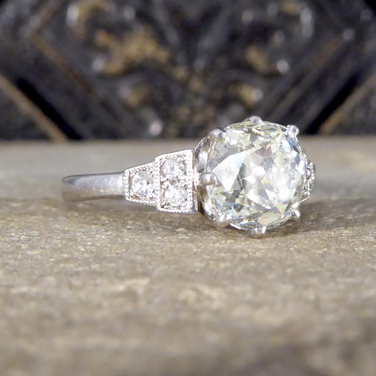 Ein wunderschön heller und funkelnder Diamant-Solitärring mit diamantbesetzten Schultern. Der Hauptdiamant in diesem Ring ist ein riesiger 1,70ct Old European Cushion Cut mit großartigem Charakter, einer klaren Reinheitseinstufung von VS1-VS2 und