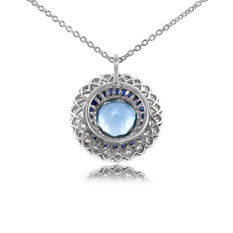 Exquisite and captivating, this Art Deco-inspired pendant is a true masterpiece. The centerpiece of this enchanting creation is an approximately 1.70-carat round aquamarine, radiating a tranquil blue hue. Embracing the aquamarine is a double halo of