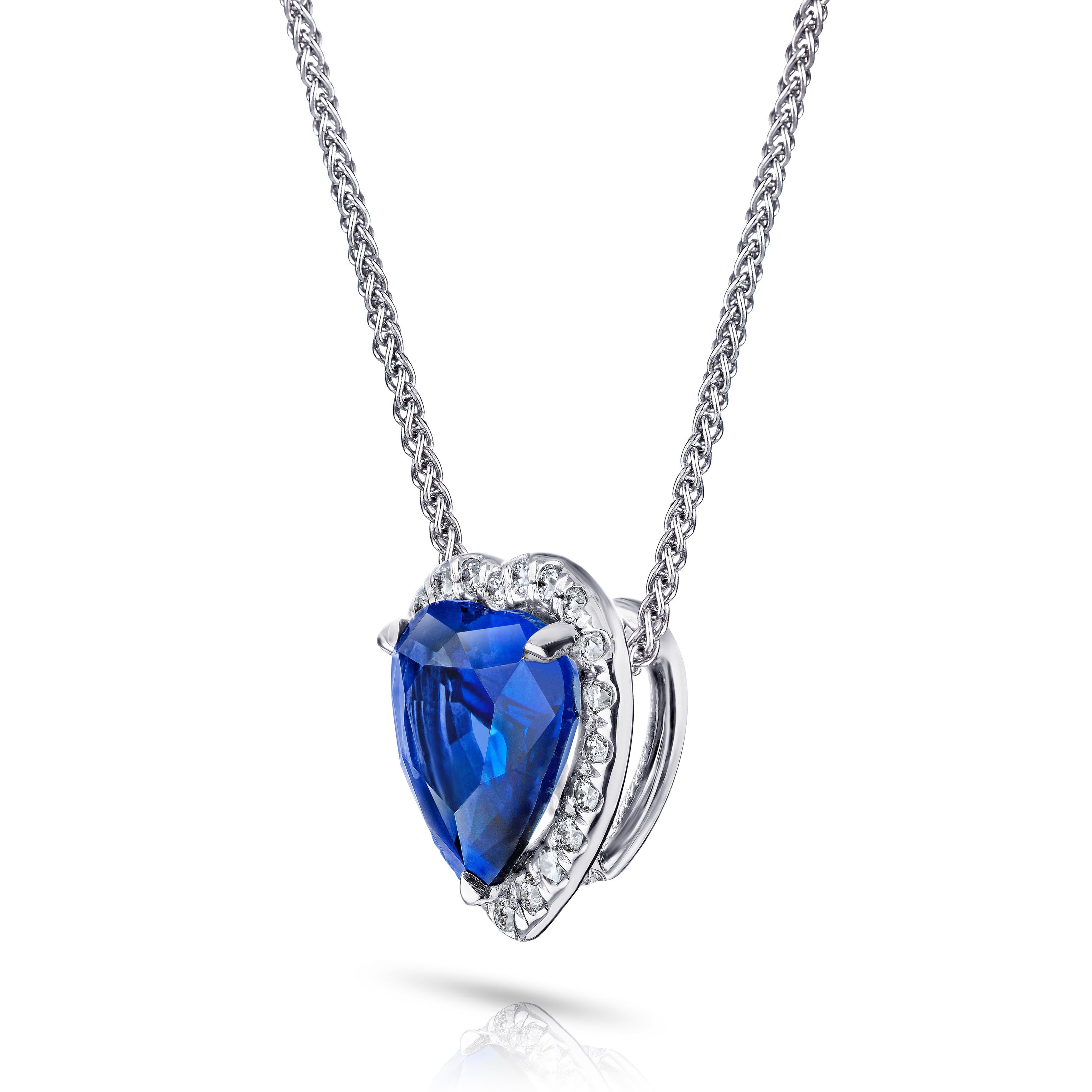 1.68 carat blue heart shape sapphire with 22 BR diamonds .10 carats set in a 18k gold pendant