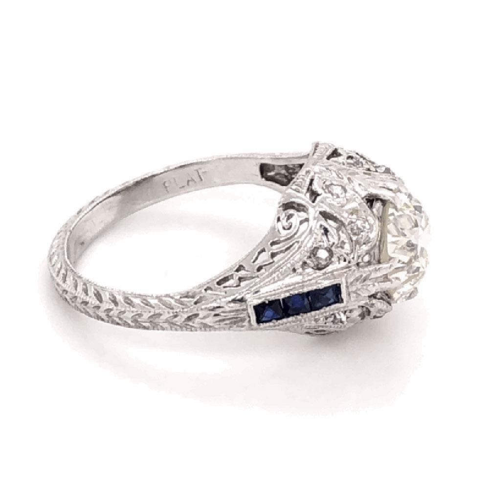 Simply Beautiful & finely detailed Art Deco Platinum Ring center set with a securely nestled Old European cut Diamond, weighing approx. 1.71 total Carat weight, side of shank set with Diamonds, approx. 0.12 total Carat weight and Blue stones.