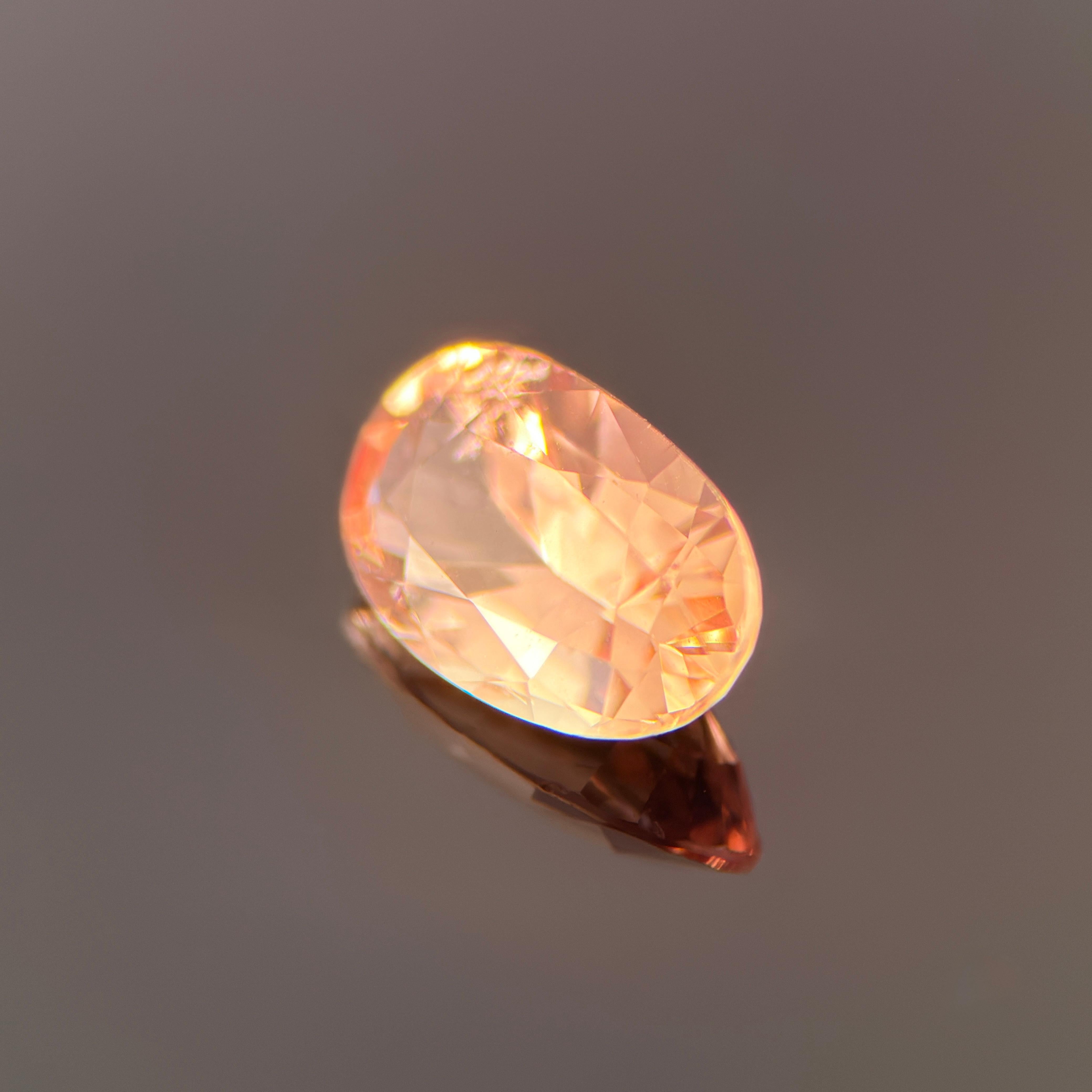 This exquisite 1.71-carat natural Padparadscha sapphire embodies one of the rarest and most celebrated color combinations in the world of gemstones — the perfect fusion of delicate pink and warm orange. Its hue shifts gracefully between coral,