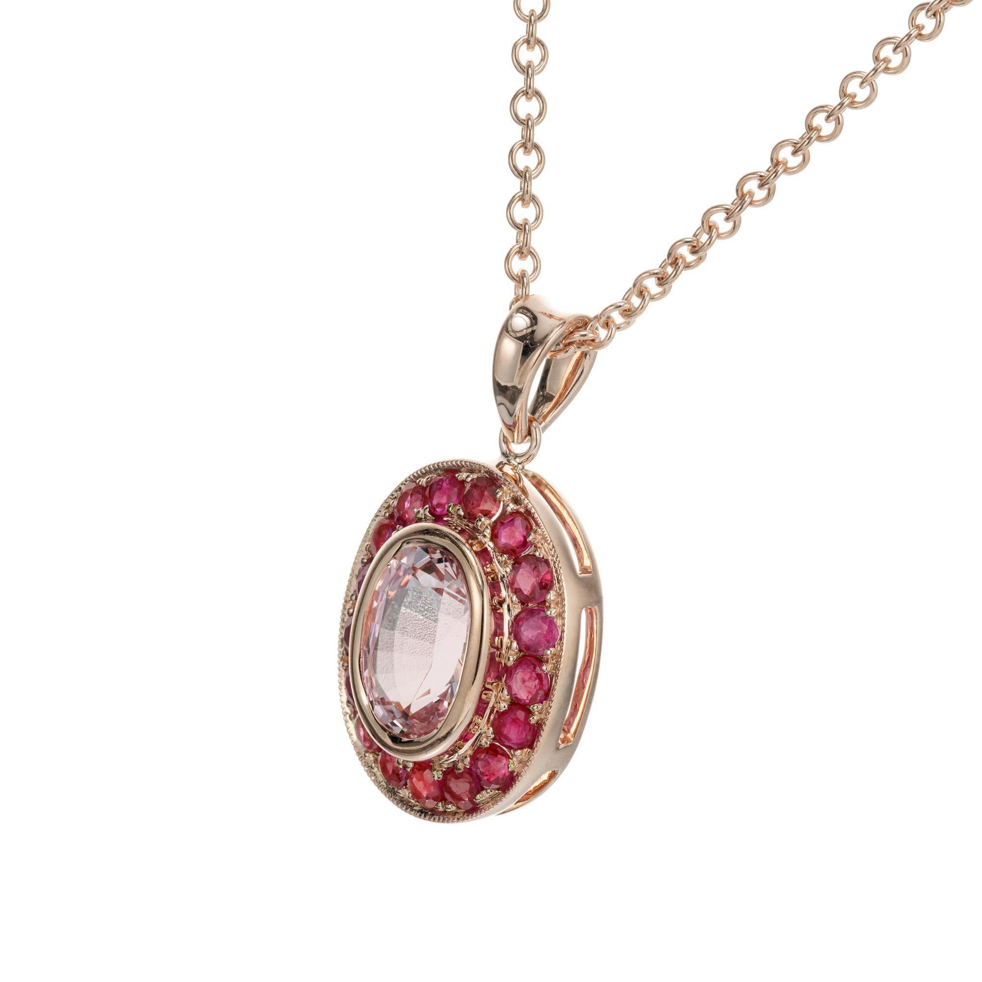 Piedra central ovalada de zafiro rosa claro suave, engastada en bisel con un halo de 17 rubíes redondos engastados en cuentas.  En la ya famosa escala de oro rosa de Peter, del 1 al 10, siendo el 10 el rosa más intenso, esta puntuación es un 8. 