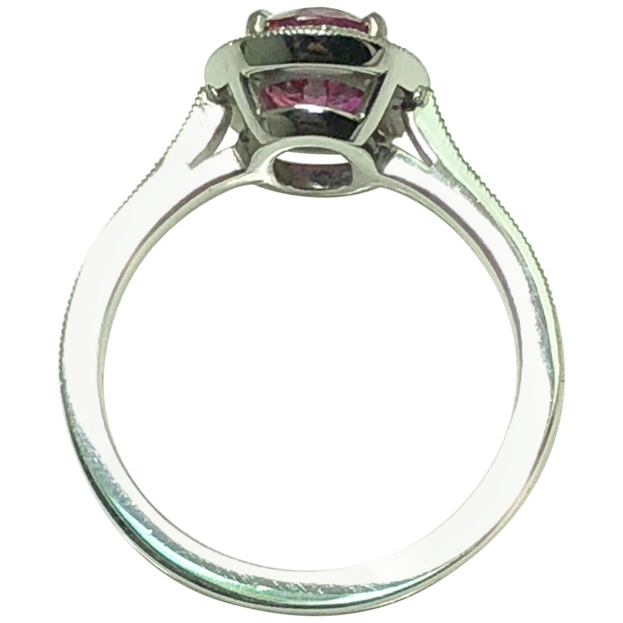 A Oval cut Ruby weighing 1.71 carats set in platinum. The ruby is set in a cluster of single cut diamonds with single cut diamond shoulders

The ring size is US 5 1/2.
