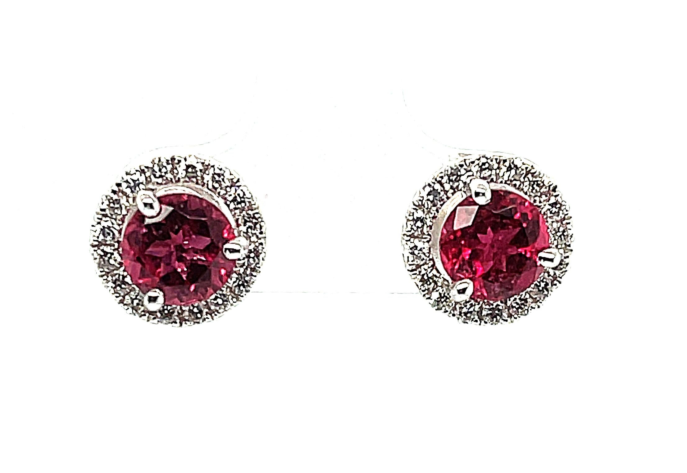 These sparkling red tourmaline and diamond halo stud earrings are real show stoppers! They feature intensely colored, fuchsia-red rubellite tourmalines surrounded by brilliant diamonds in a classic and elegant, yet very wearable design. These gems