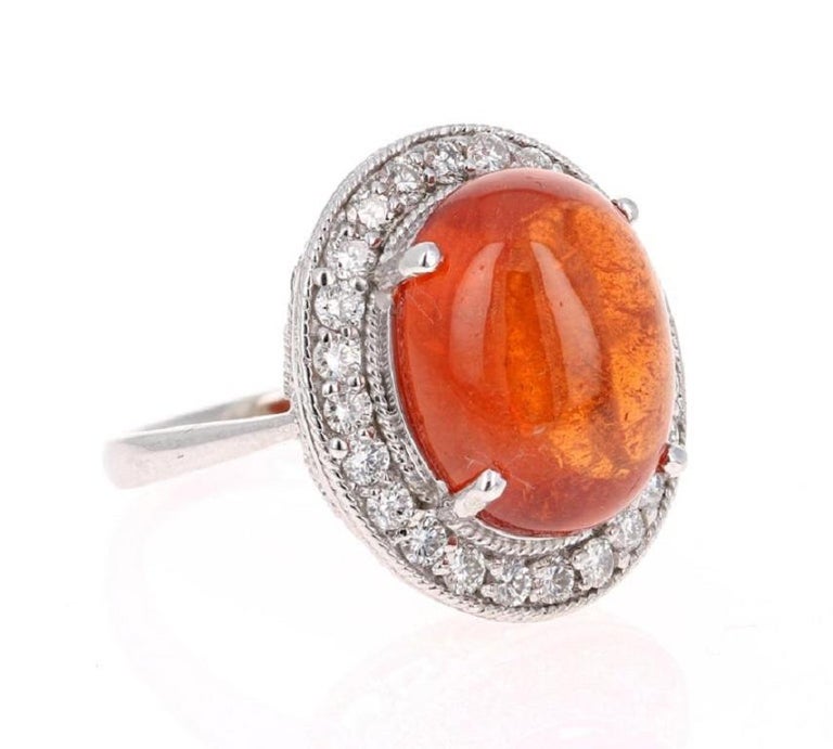 This stunner has a large Cabochon Oval Cut Mandarin Garnet that weighs 16.16 Carats and is surrounded by 24 Round Cut Diamonds that weigh 0.95 Carats. The total carat weight of the ring is 17.11 carats.

The ring is beautifully crafted in 14K White