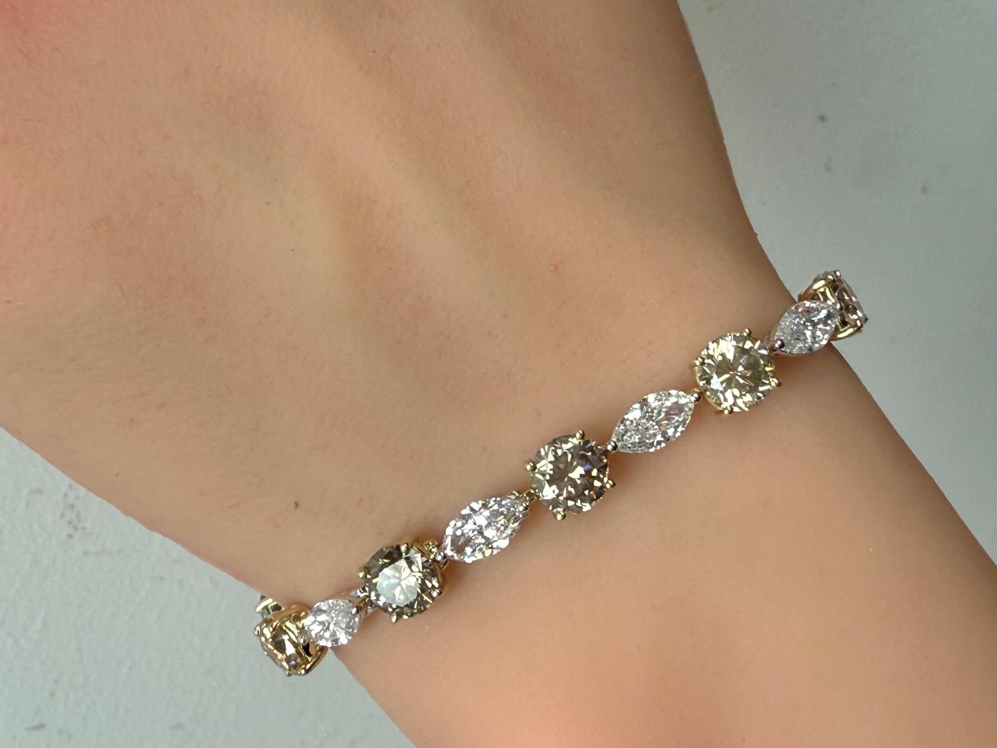 Esta pulsera de tenis de oro amarillo y blanco de 14 quilates, con once diamantes brillantes marquesa, pesan 5,97 quilates de color E-F y claridad VS2-SI1 y once diamantes brillantes redondos marrones, pesan 11,22 quilates.  Esta pulsera presenta un