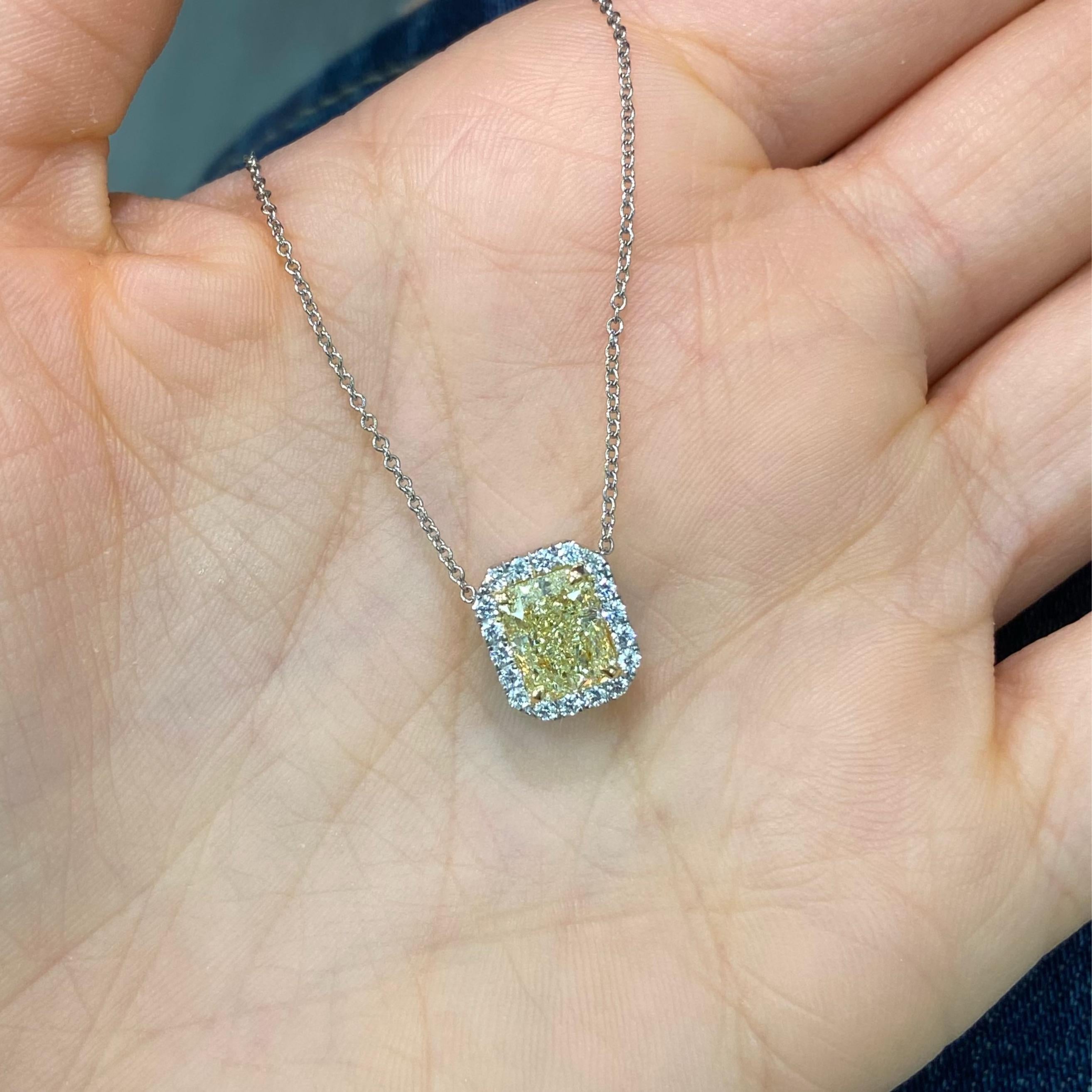 This elegant 1.71 carat light yellow diamond pendant necklace features a beautifully elongated radiant cut diamond in the W-X color range, offering a soft, golden glow. With VS1 clarity, excellent cutting, and no fluorescence, the center stone is